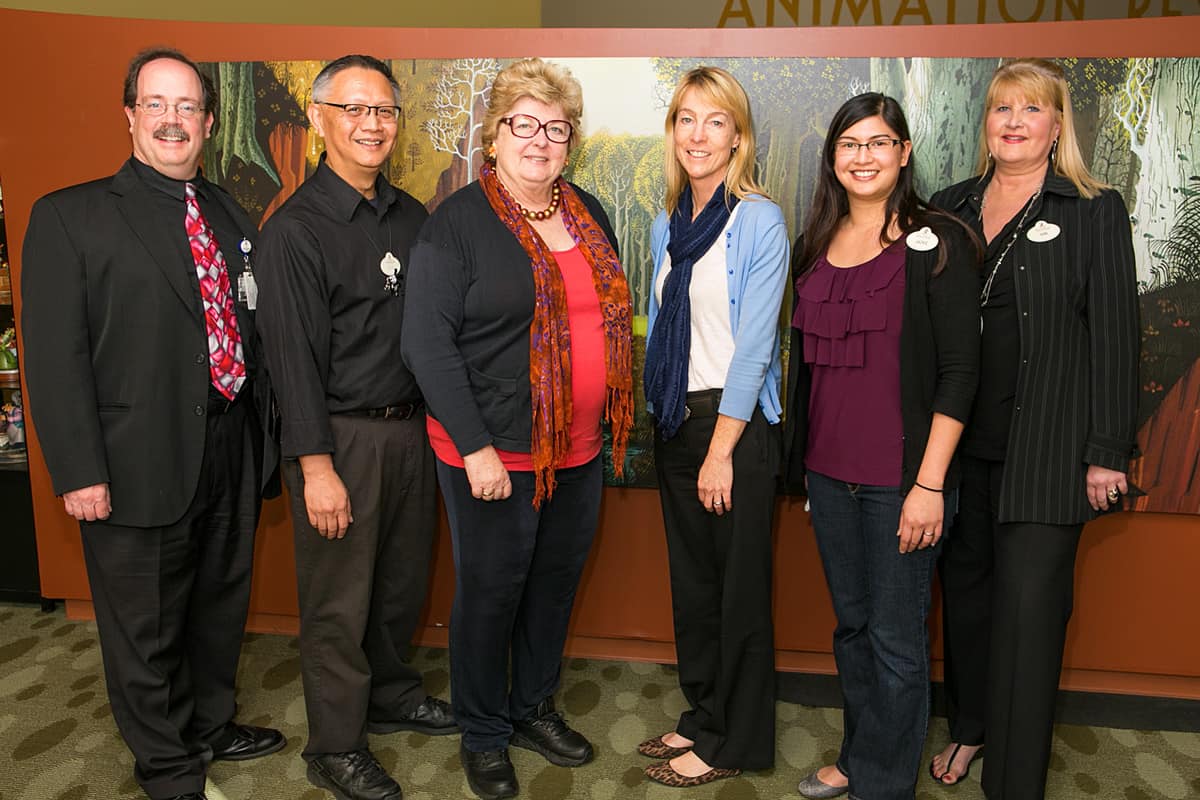 Group of professionals posing for a photo at the Disney Animation Research Library event.