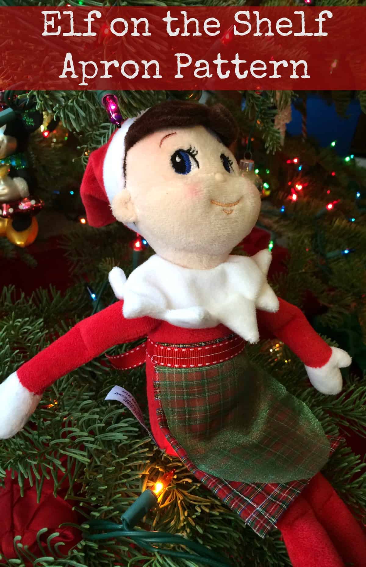 A elf sitting next to a christmas tree