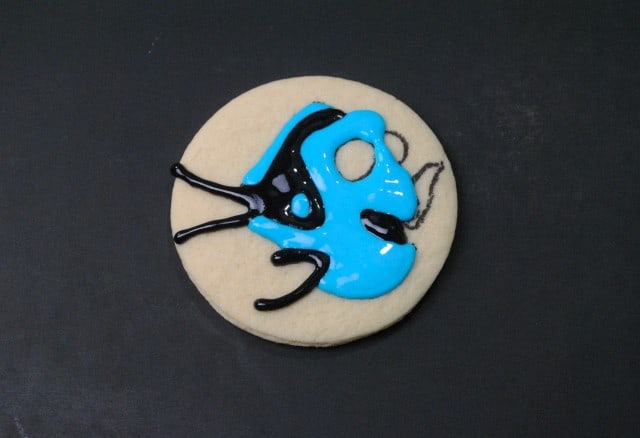 A Finding Dory Sugar Cookie with blue and black icing designed to resemble an abstract art pattern.