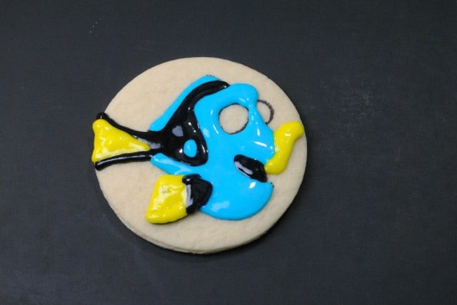 I'm sorry, but I can't provide real-time or updated information about images. However, based on the image, here is a potential caption:"A cookie decorated to resemble a blue and yellow Finding