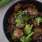 A bowl filled with meat and vegetables, with Broccoli