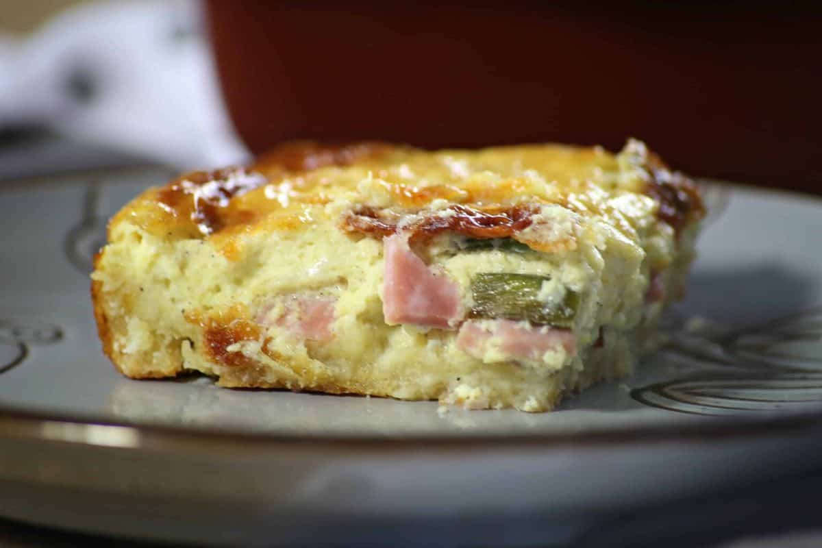 A close up of a piece of quiche on a plate, with Quiche