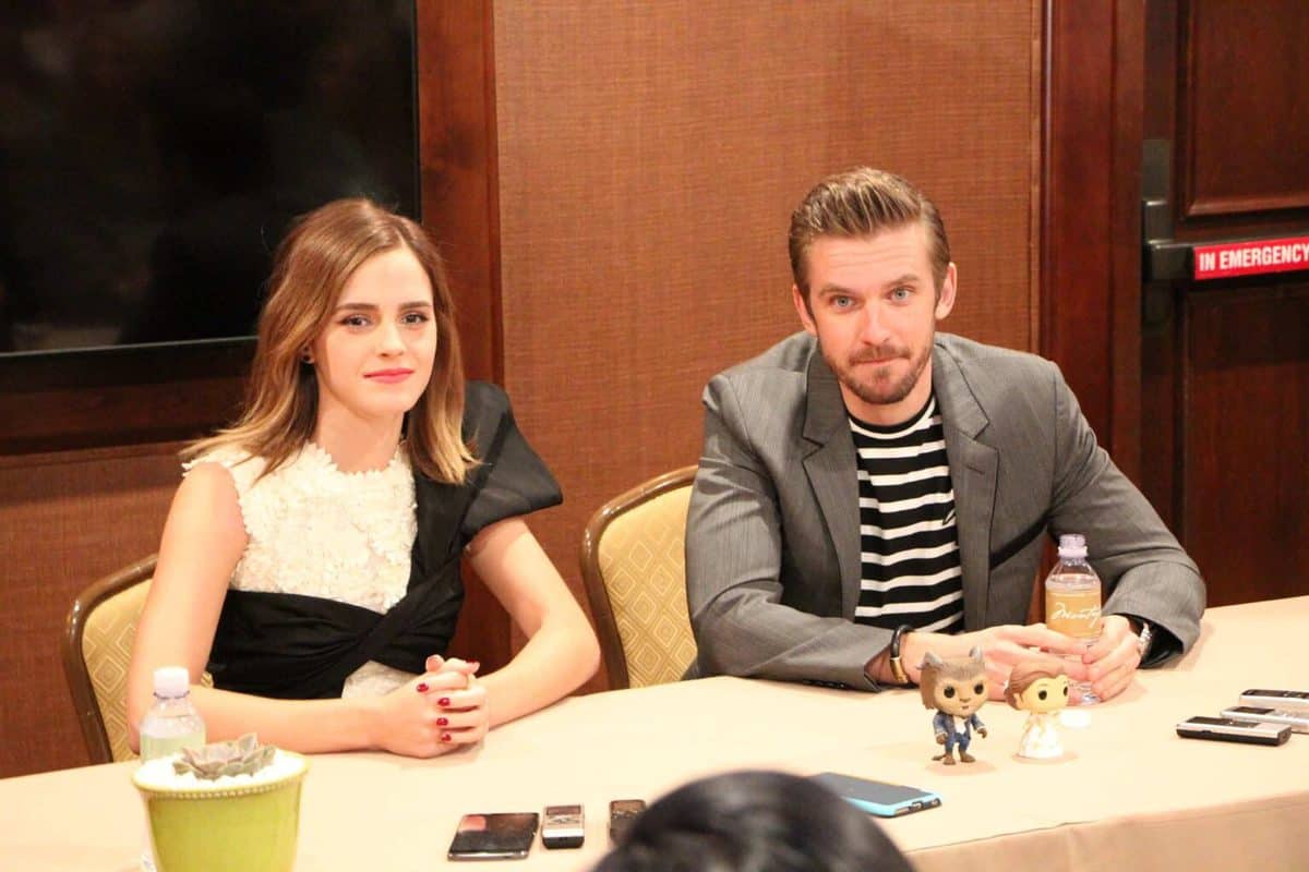 Emma Watson, Dan Stevens sitting at a table