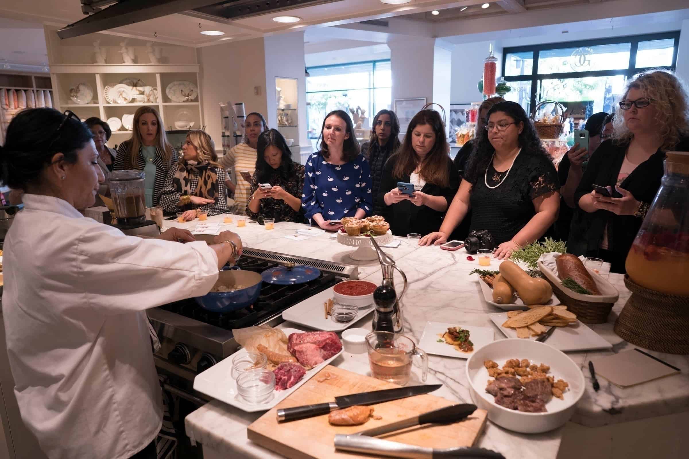 A group of people standing around a table eating food