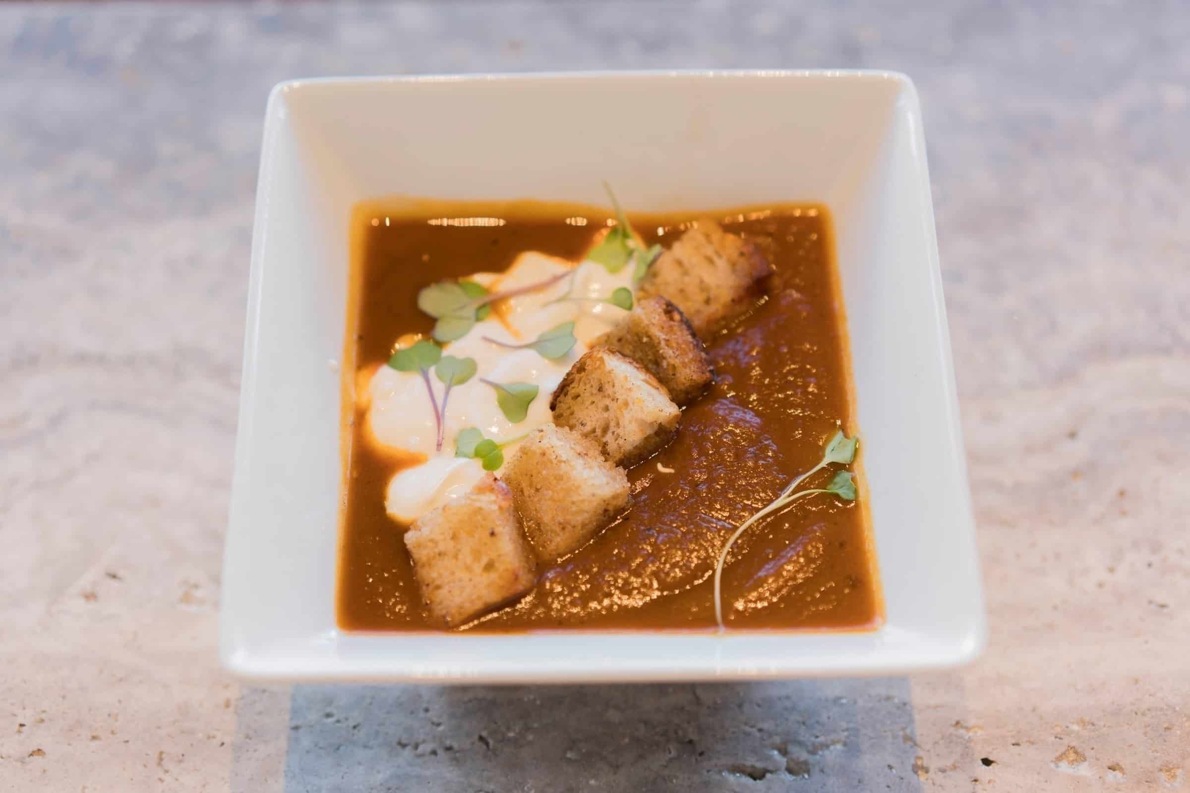 A plastic container of food, with Soup