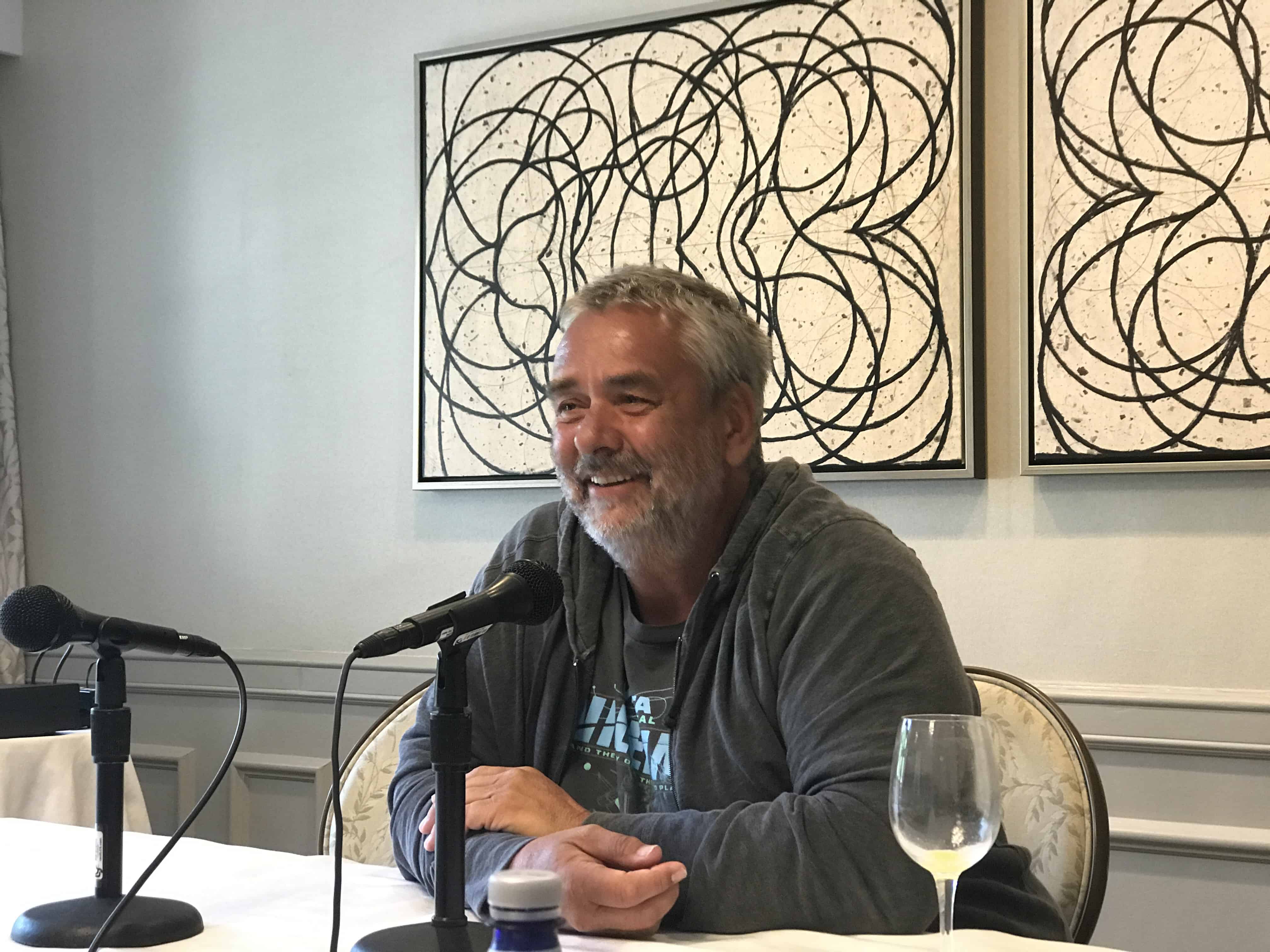 Luc Besson sitting at a table