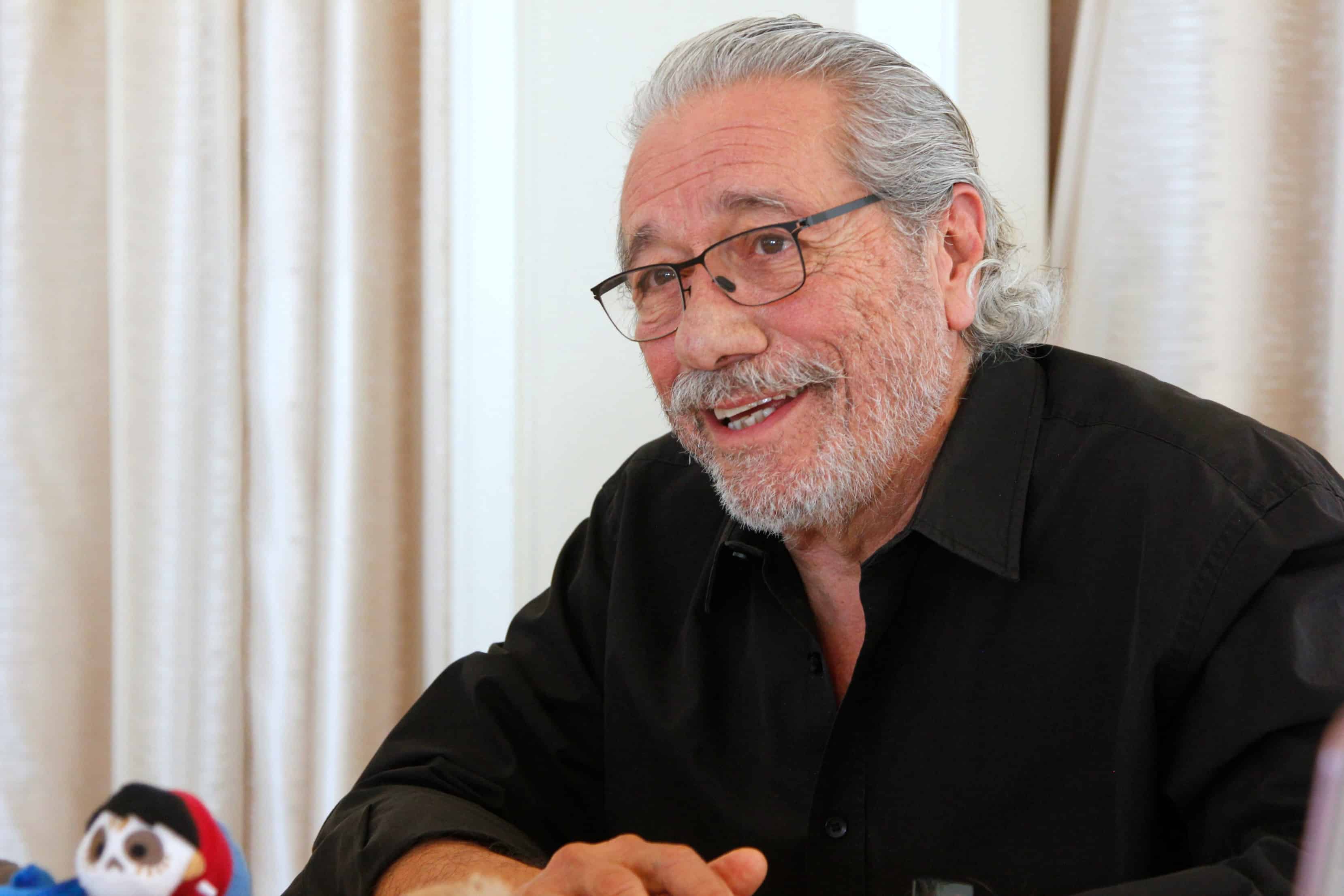 Edward James Olmos sitting in front of a curtain