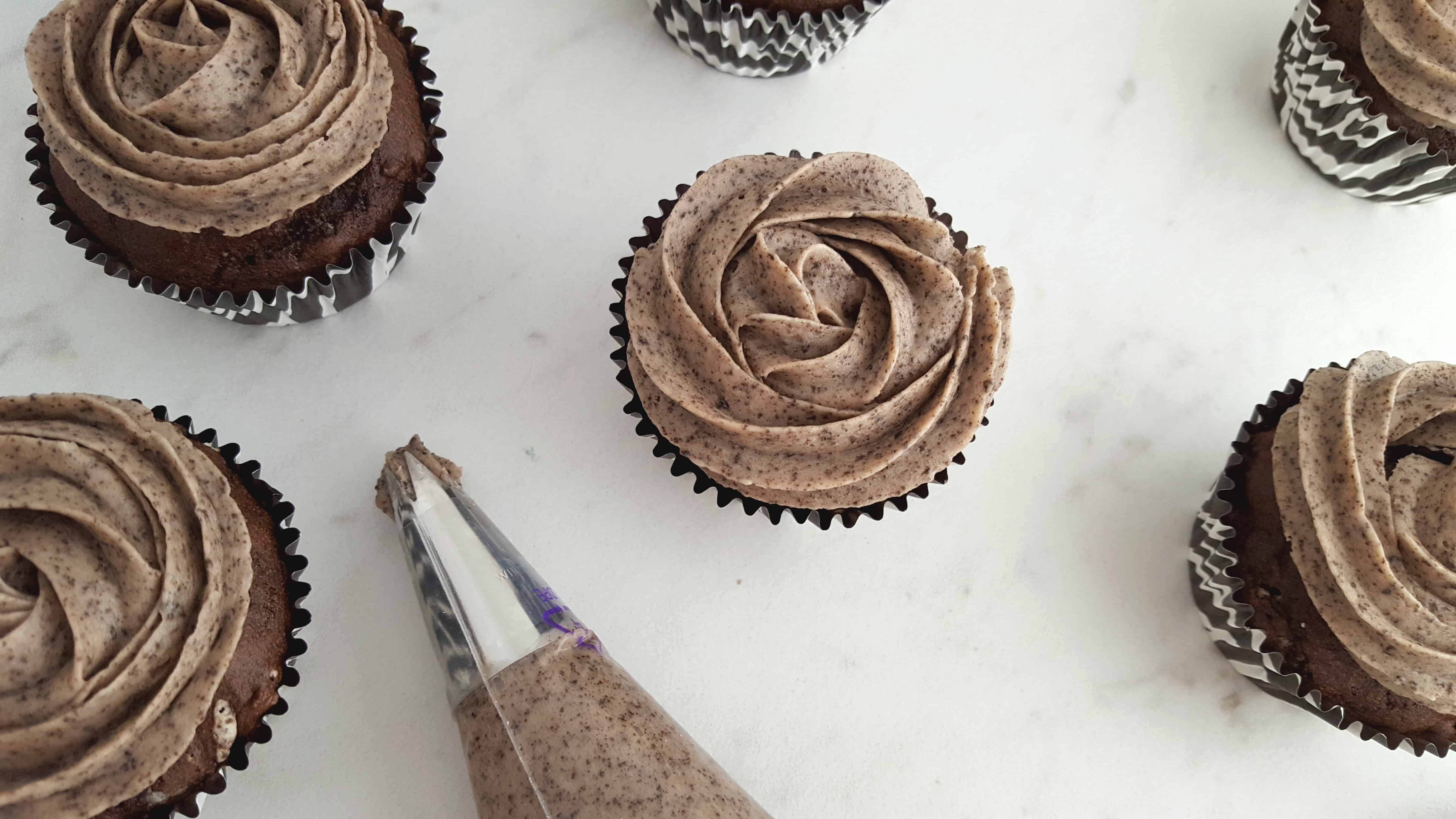 A large chocolate cake on a plate, with Cookie and Cupcake