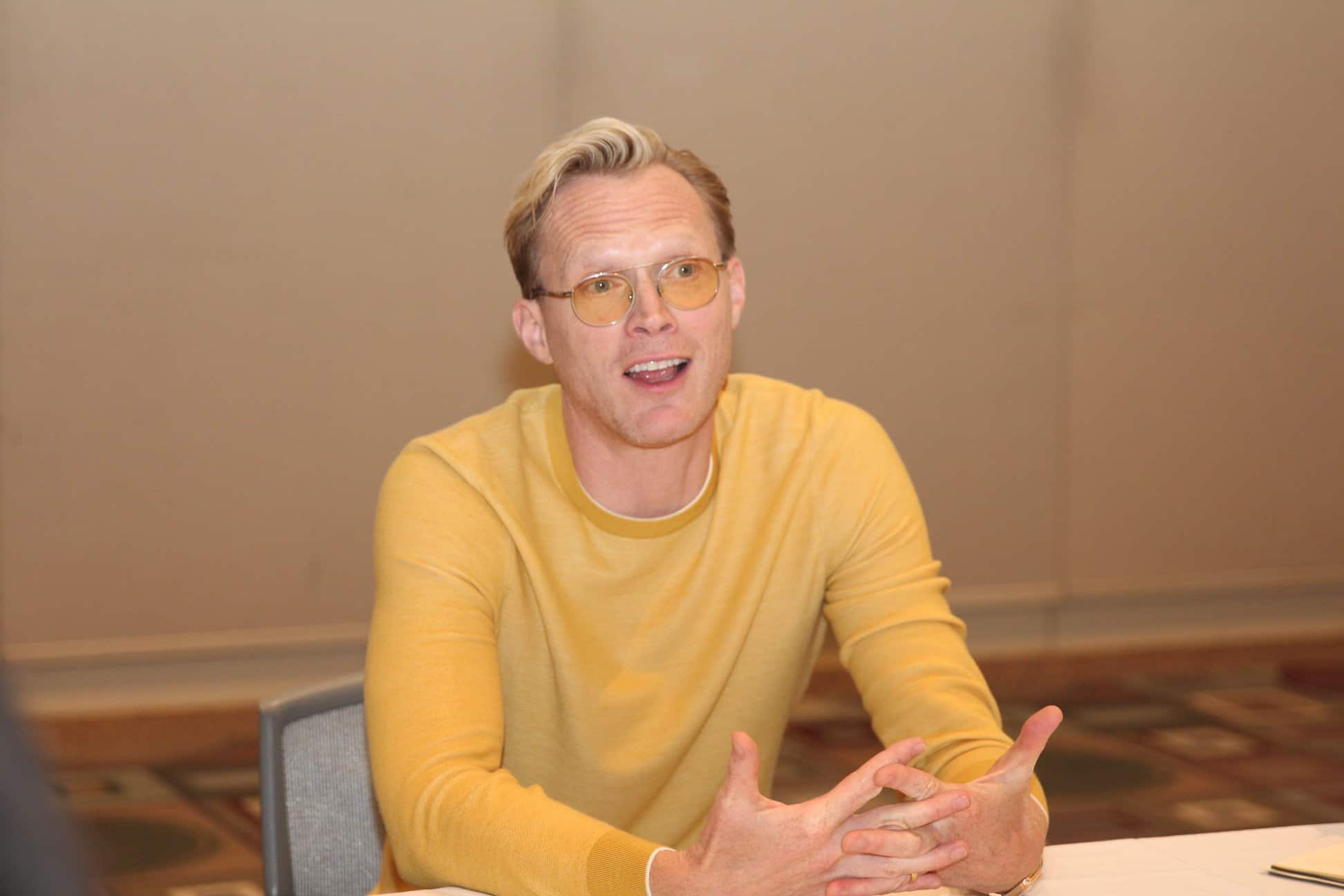 Paul Bettany sitting on a table