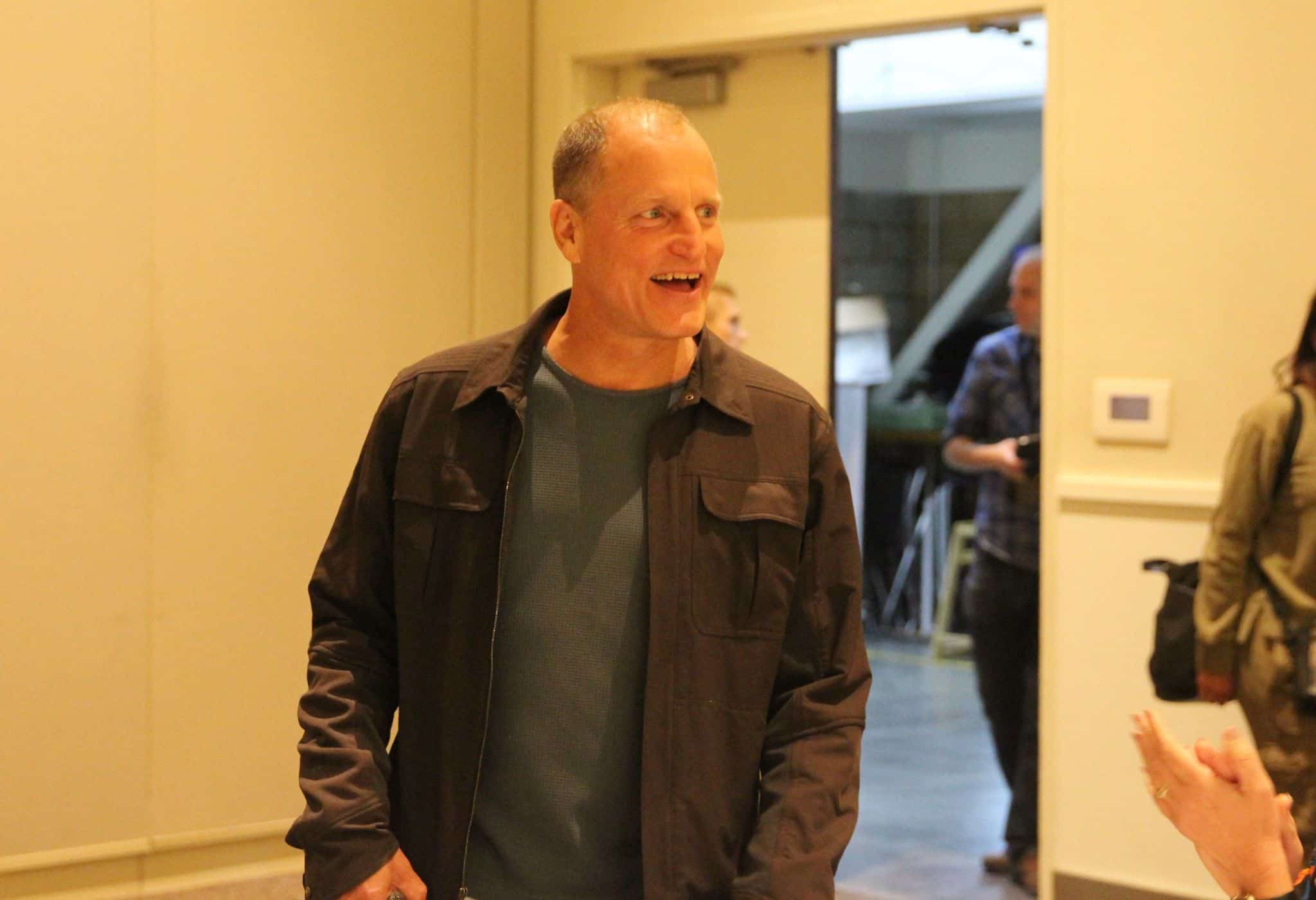 Woody Harrelson standing next to a woman