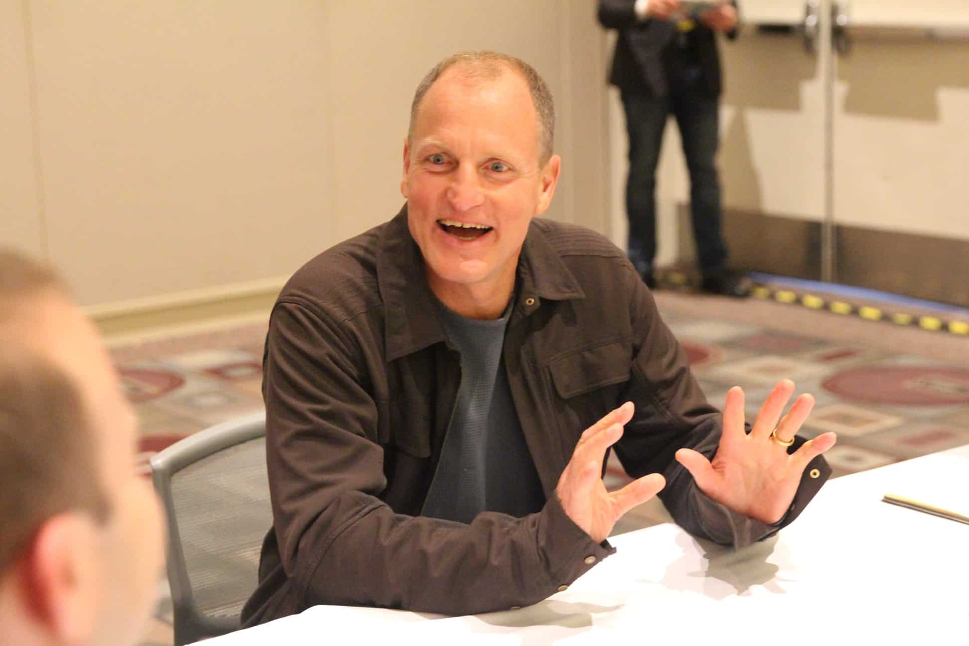 Woody Harrelson sitting on a table