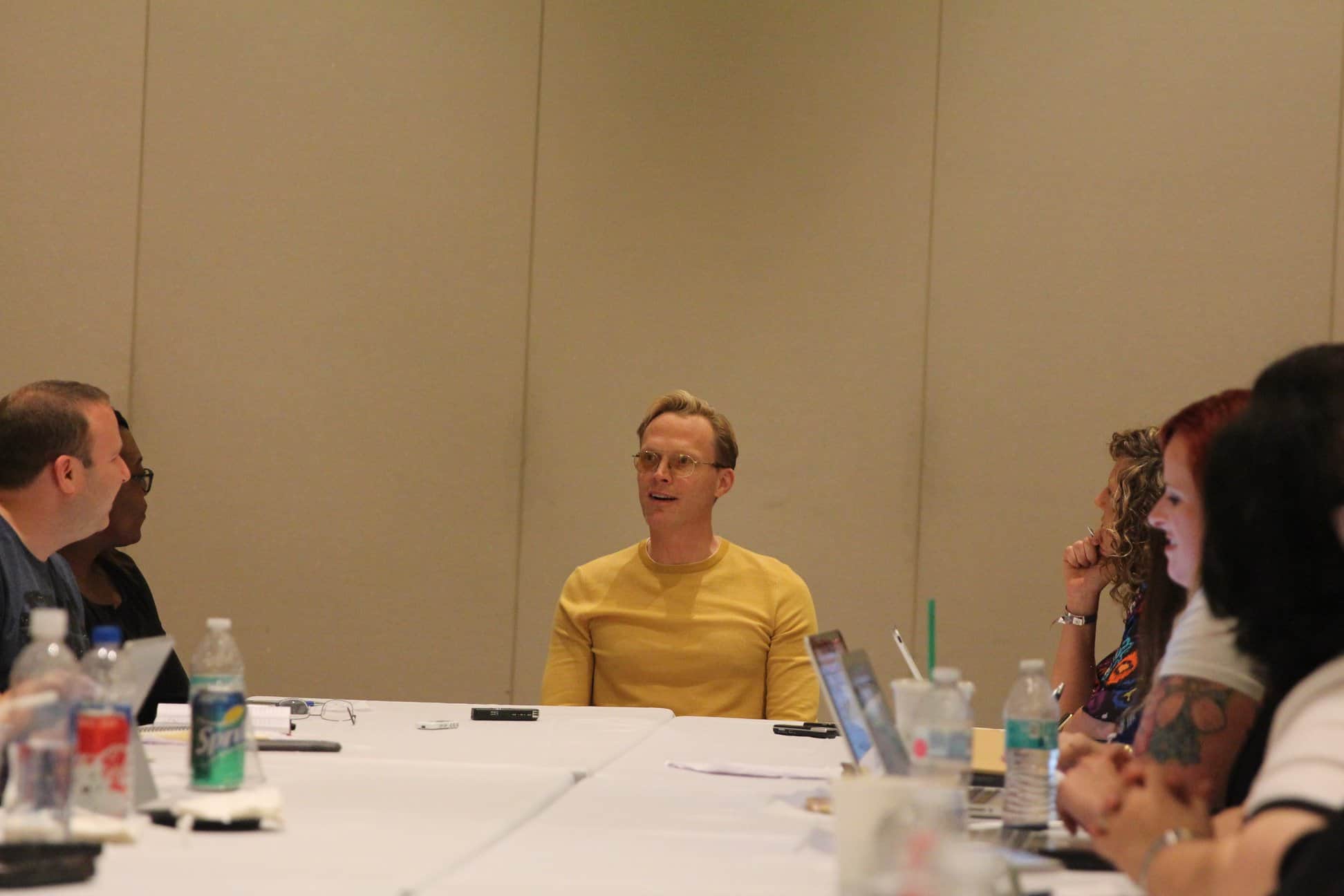 Paul Bettany et al. sitting at a table
