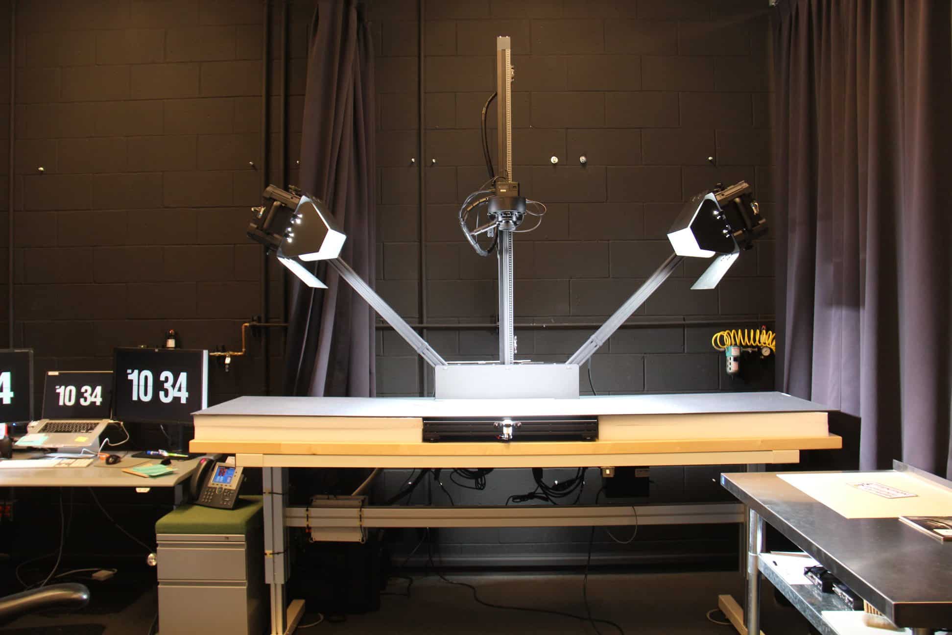 A desk with a computer in front of a mirror posing for the camera