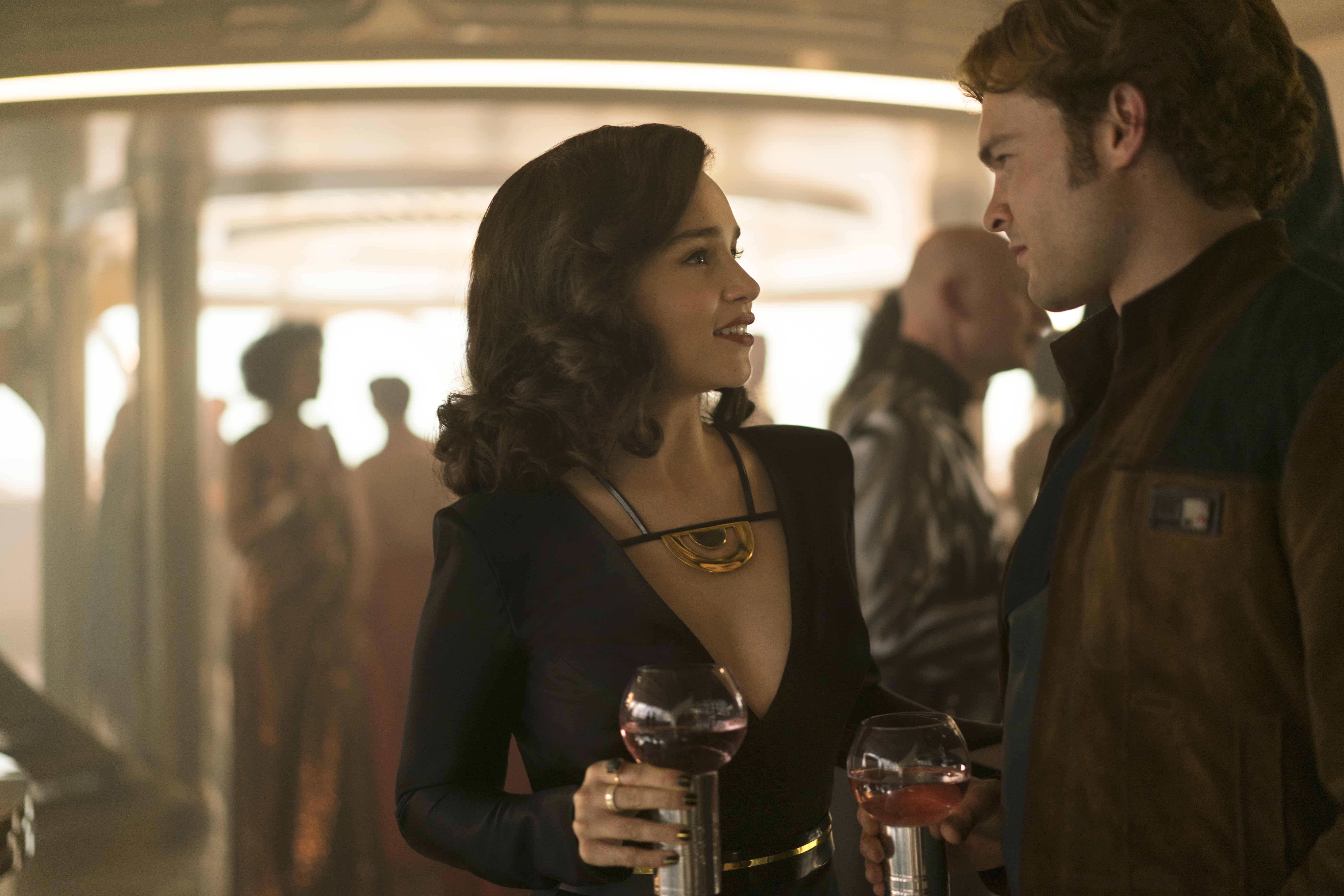 A man and a woman standing next to a glass of wine, with Star Wars