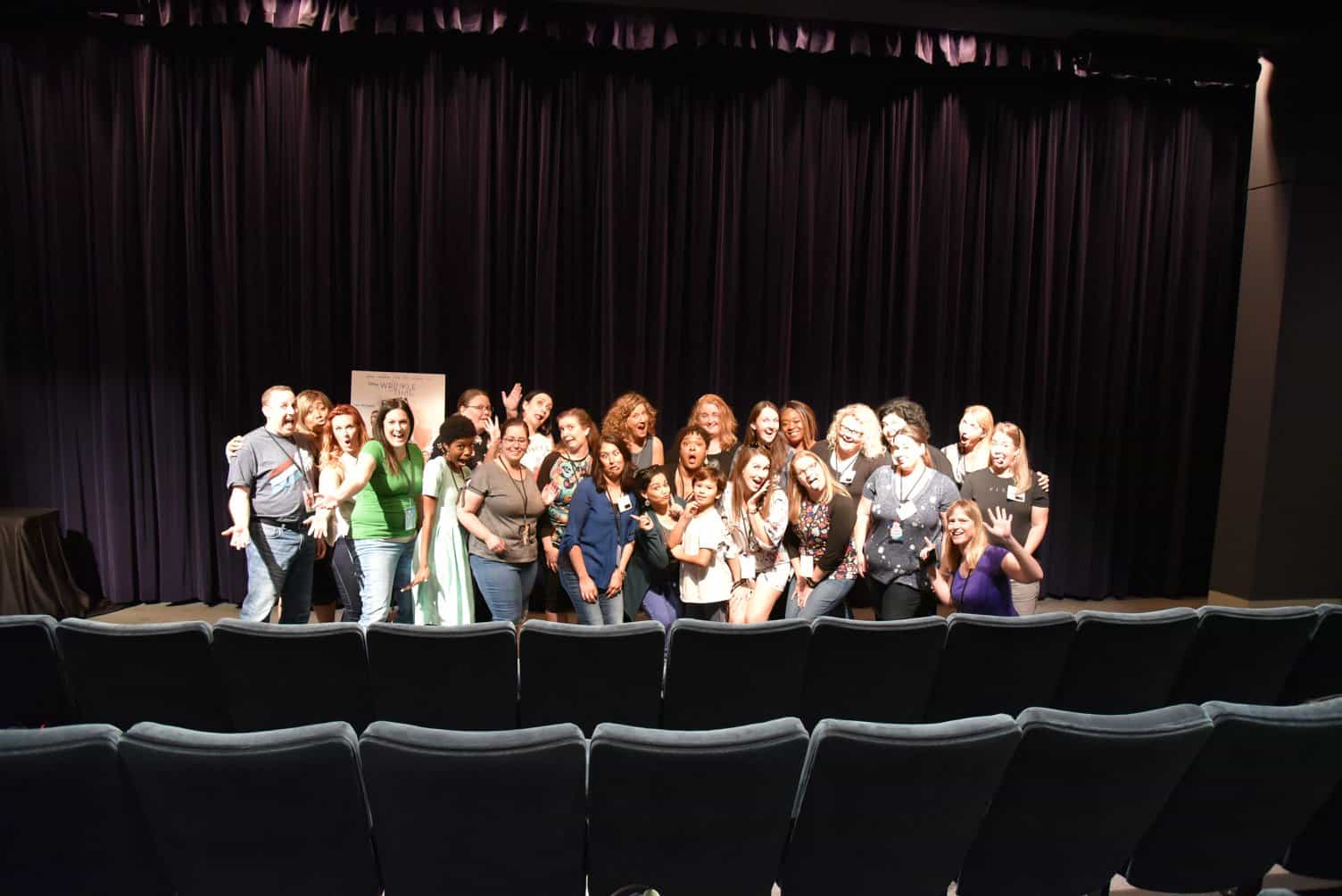 A group of people standing in front of a curtain
