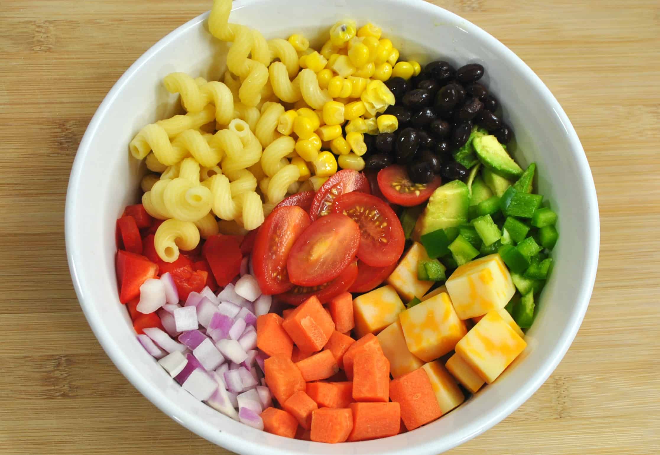 A bowl of fruit on a plate, with Salad and Pasta