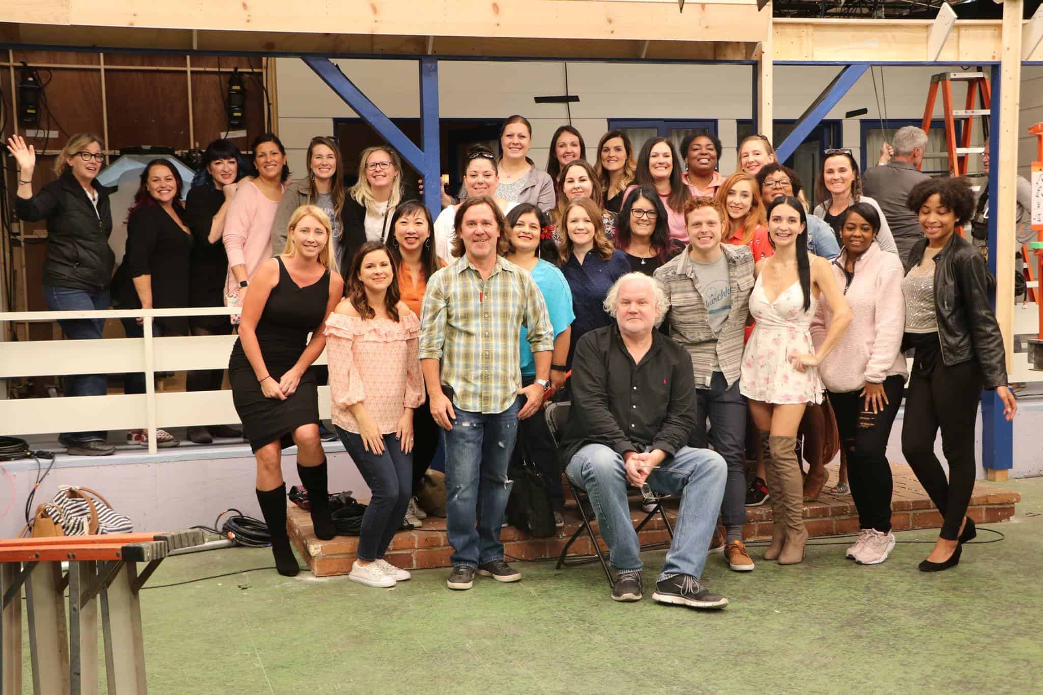 A group of people standing in front of a crowd posing for the camera