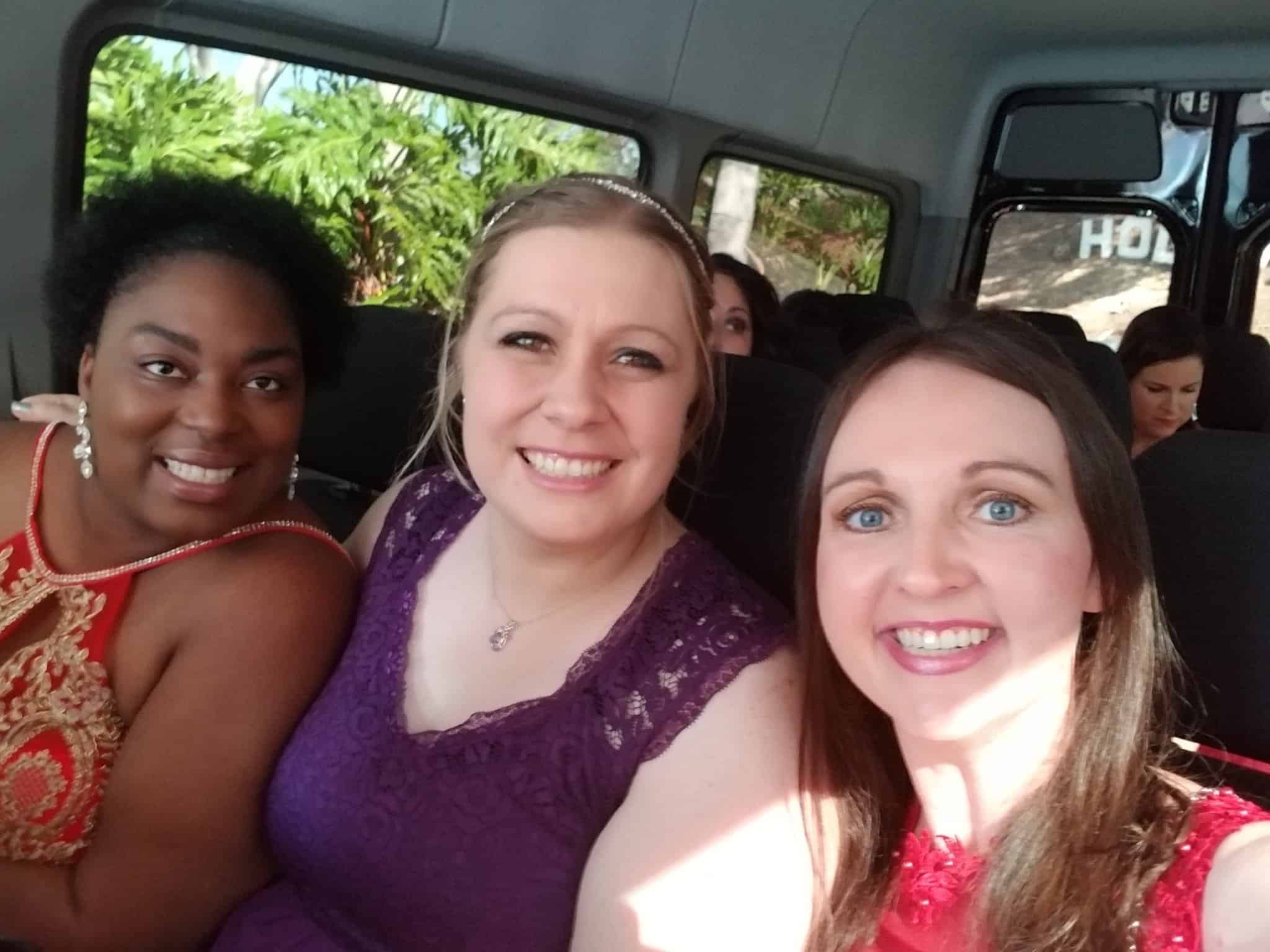 A group of people sitting in a car posing for the camera
