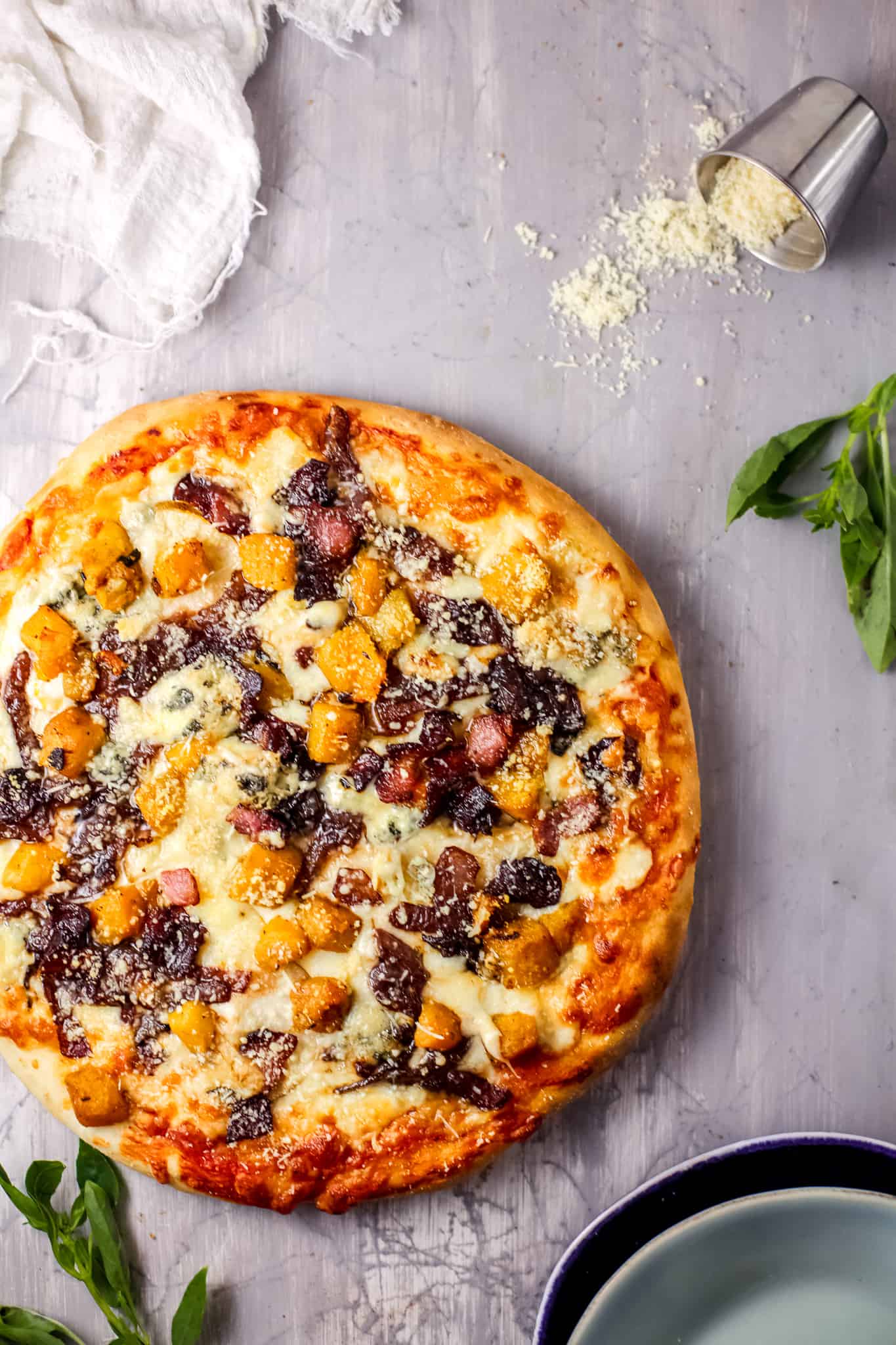 A pizza sitting on top of a pan, with Pumpkin and Cheese