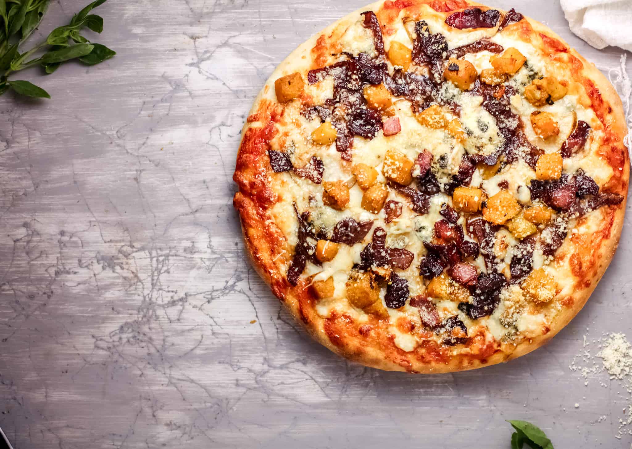 A pizza sitting on top of a cutting board, with Cheese and Harvest
