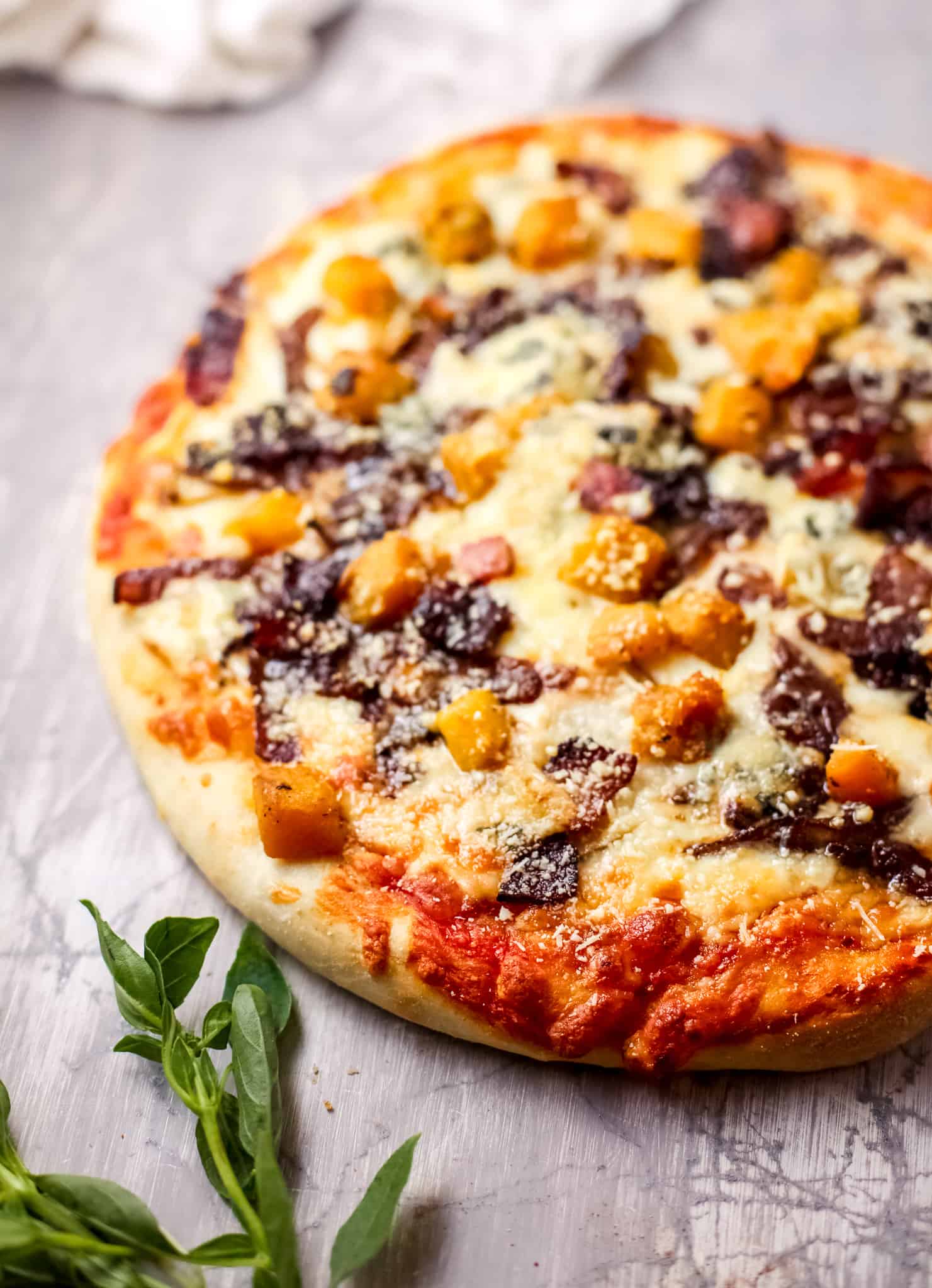 A pizza sitting on top of a wooden cutting board, with Cheese and Harvest