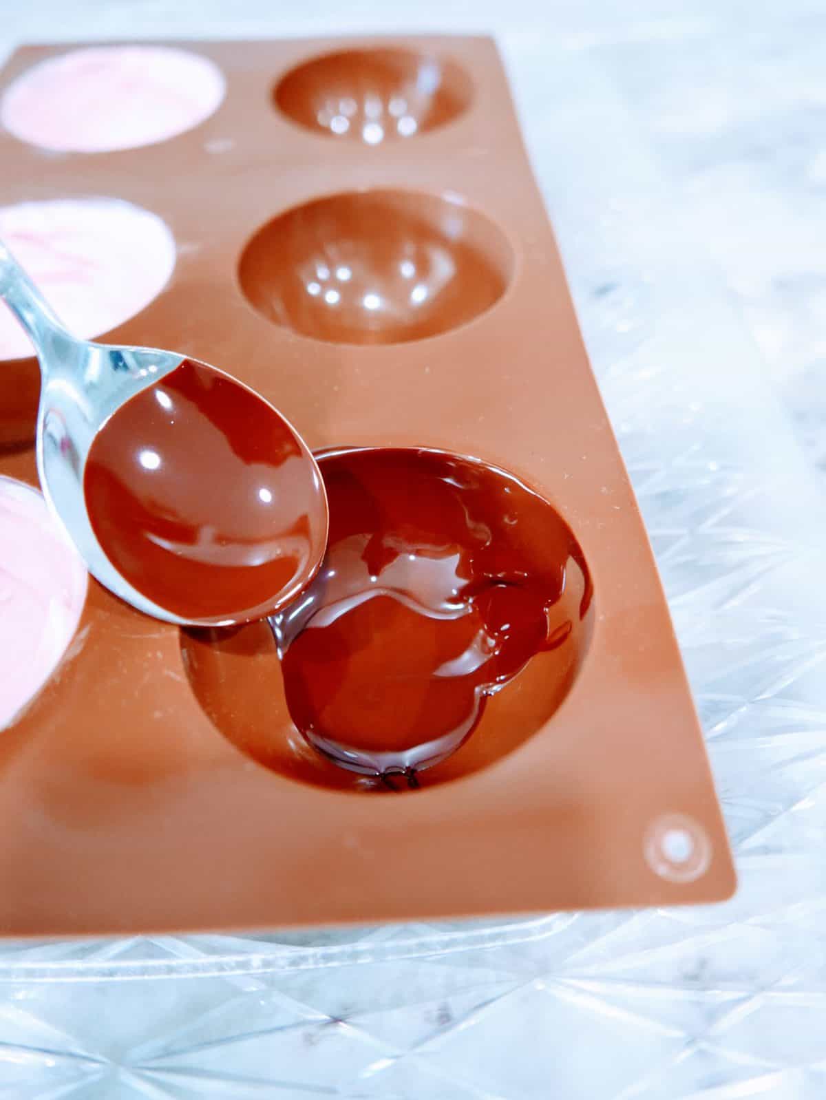 Pouring melted chocolate into a mold.