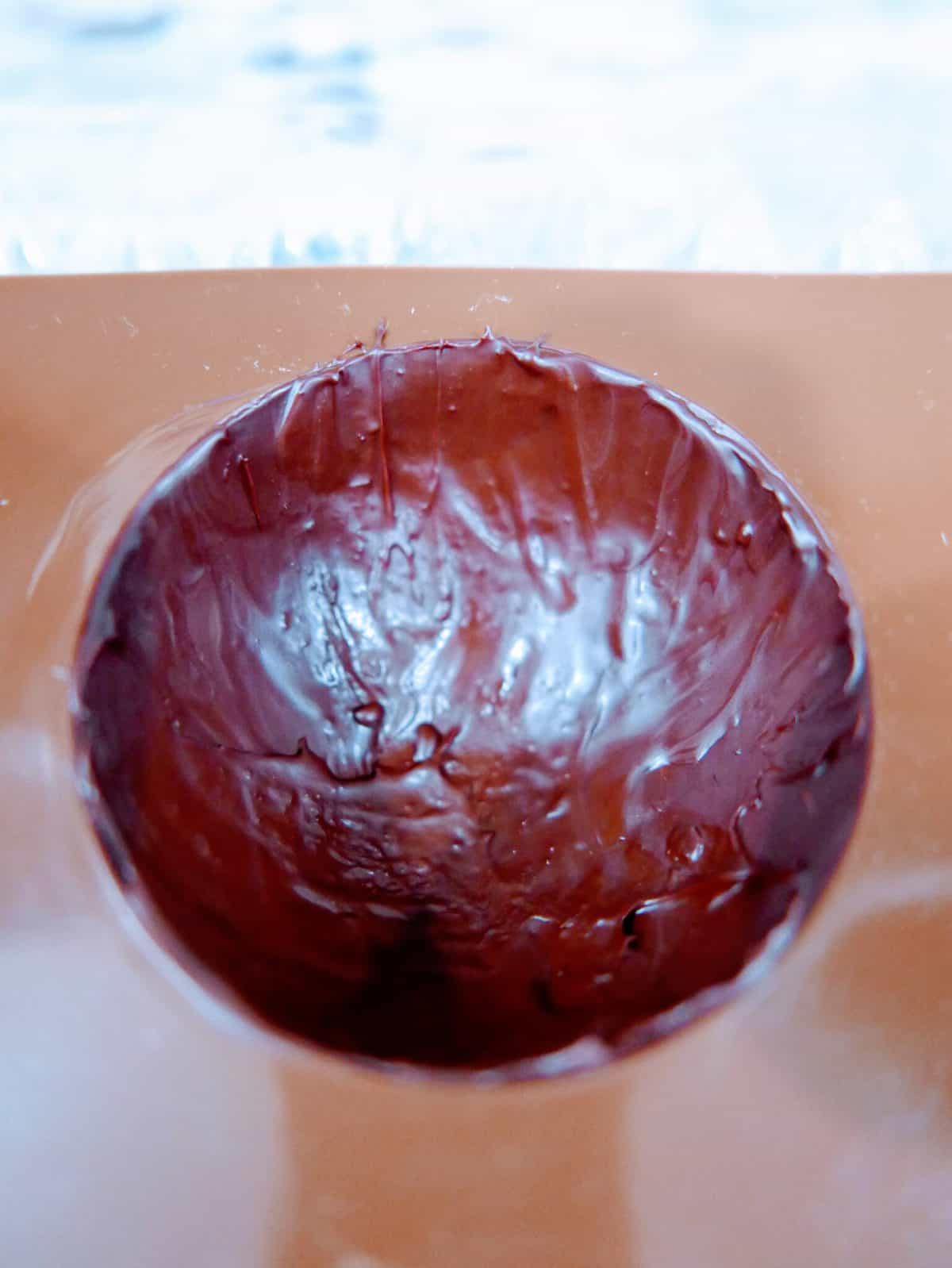 Close-up of a hollow chocolate easter egg with a bitten edge.