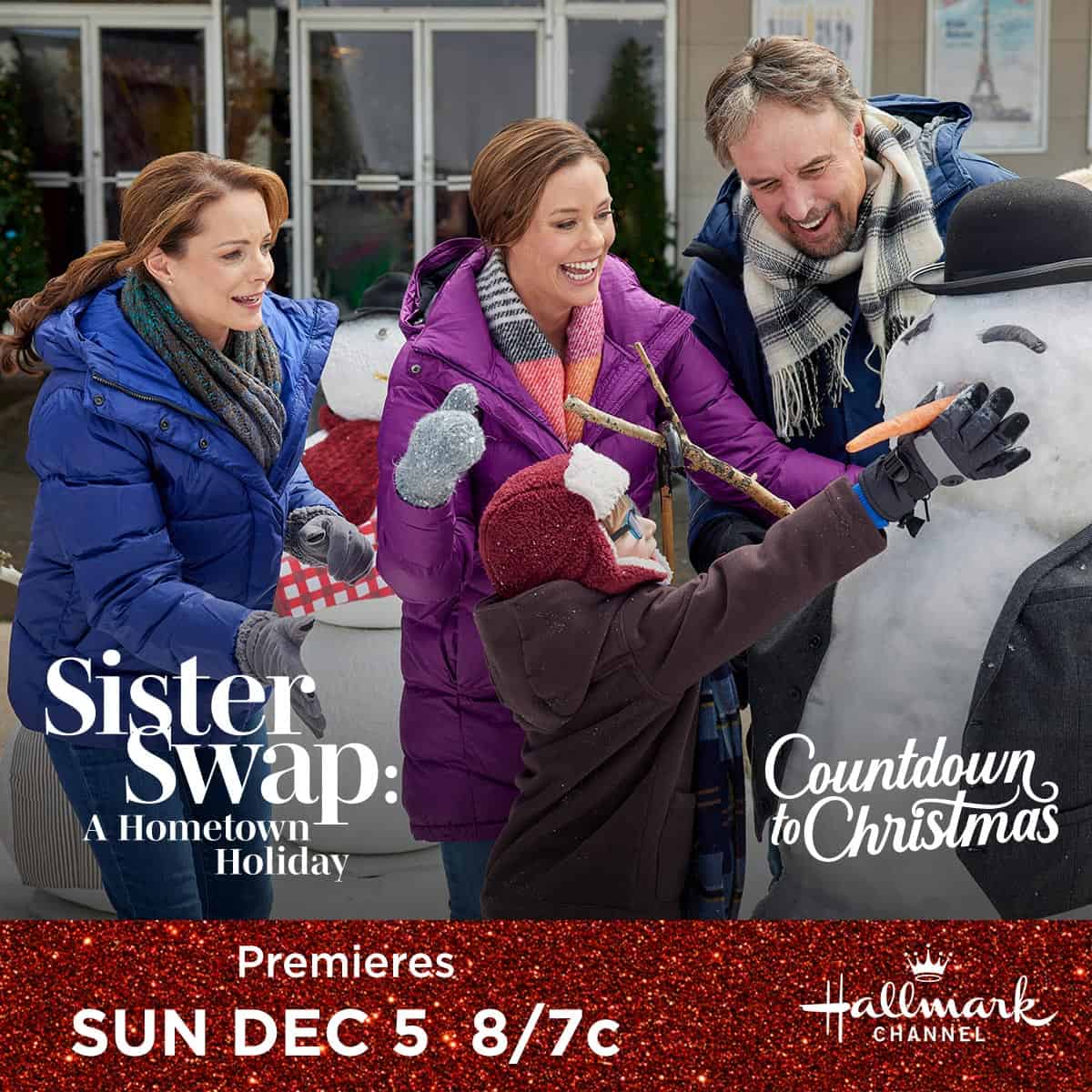 Three people are decorating a snowman in a festive atmosphere as a promotion for the Hallmark Channel's "Sister Swap: A Hometown Holiday" movie premiere.