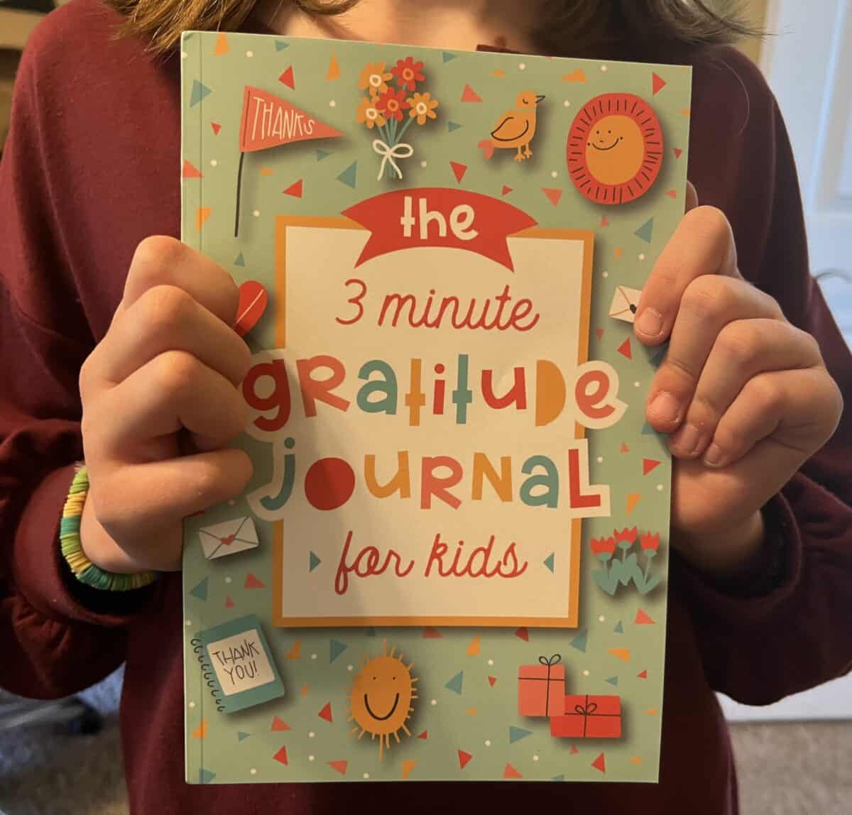 Girl holding gratitude journal