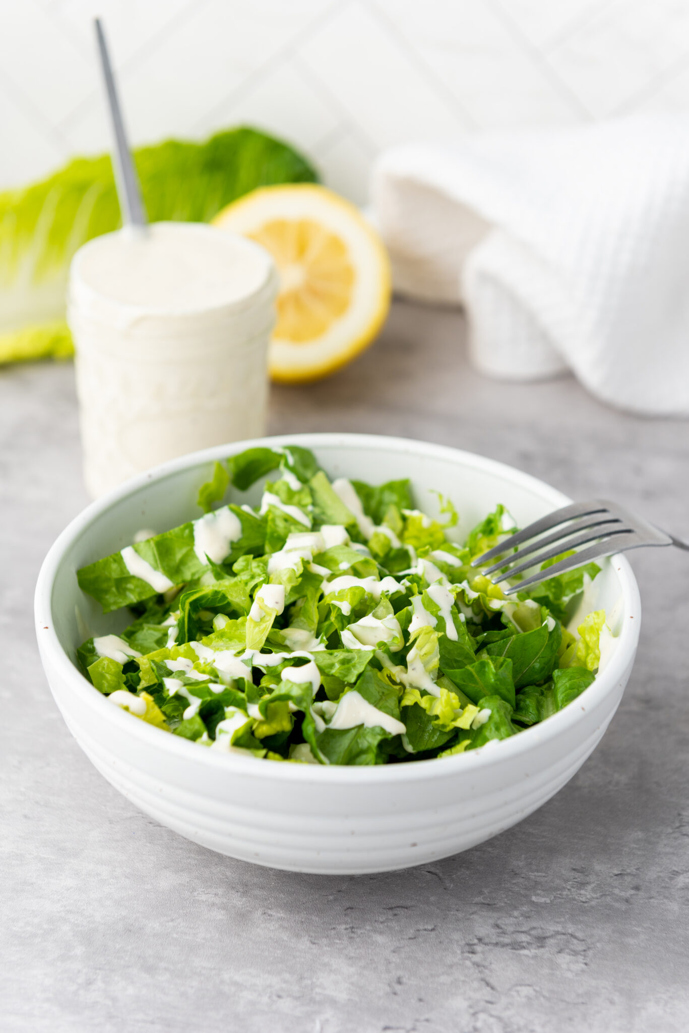 A vibrant Caesar salad with crisp romaine lettuce, generously drizzled with the creamy dressing.