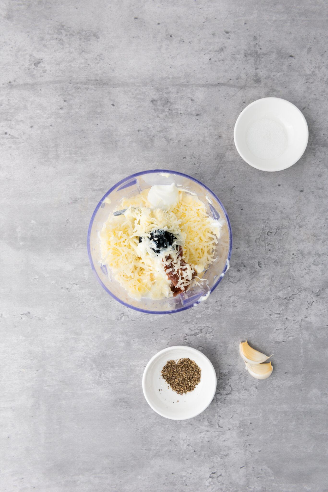 Minced garlic cloves being dropped in, with their signature texture and bits evident.
