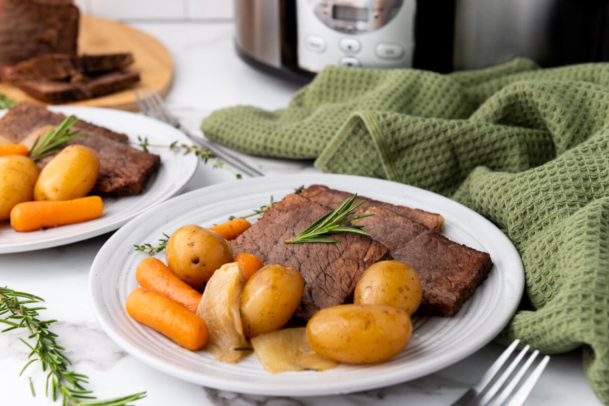 A perfectly set dinner table featuring the main dish centerpiece, complemented by steaming sides, ready for serving.