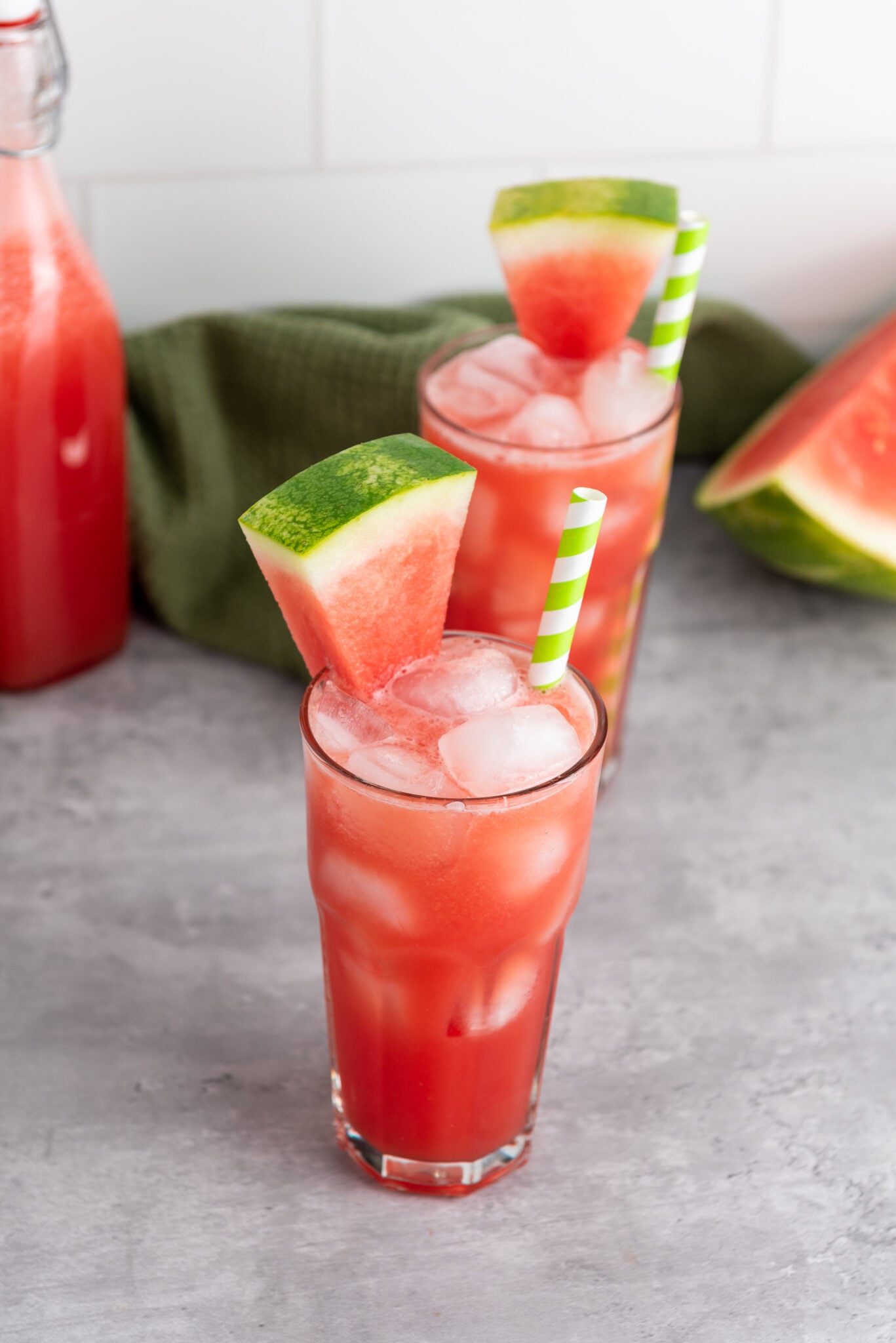 A chilled glass of watermelon juice with a straw, perfect for a hot day.