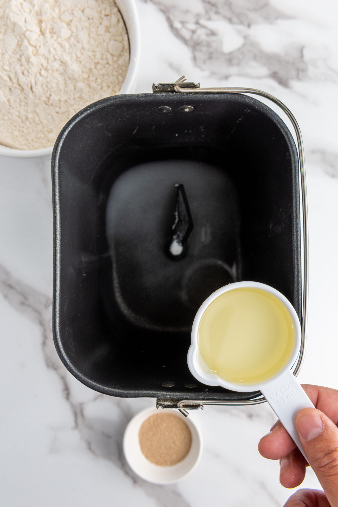 Vegetable oil being drizzled into the bread pan.