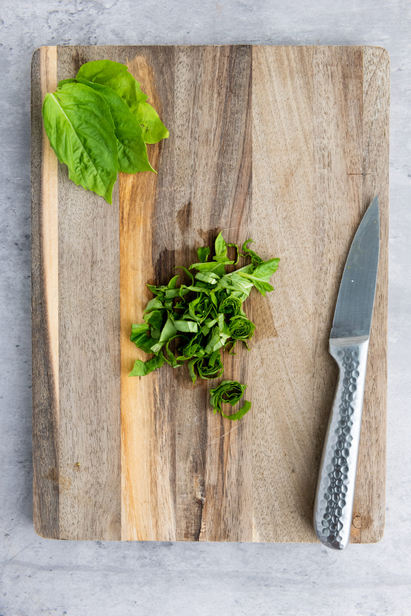 Basil leaves being rolled for thin slicing.