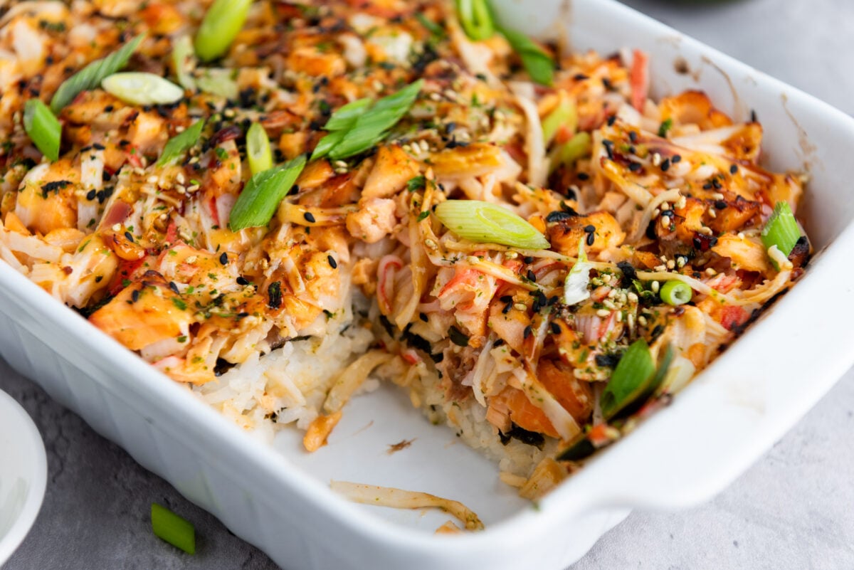 Finished sushi bake in a casserole dish, beautifully browned top with visible layers.