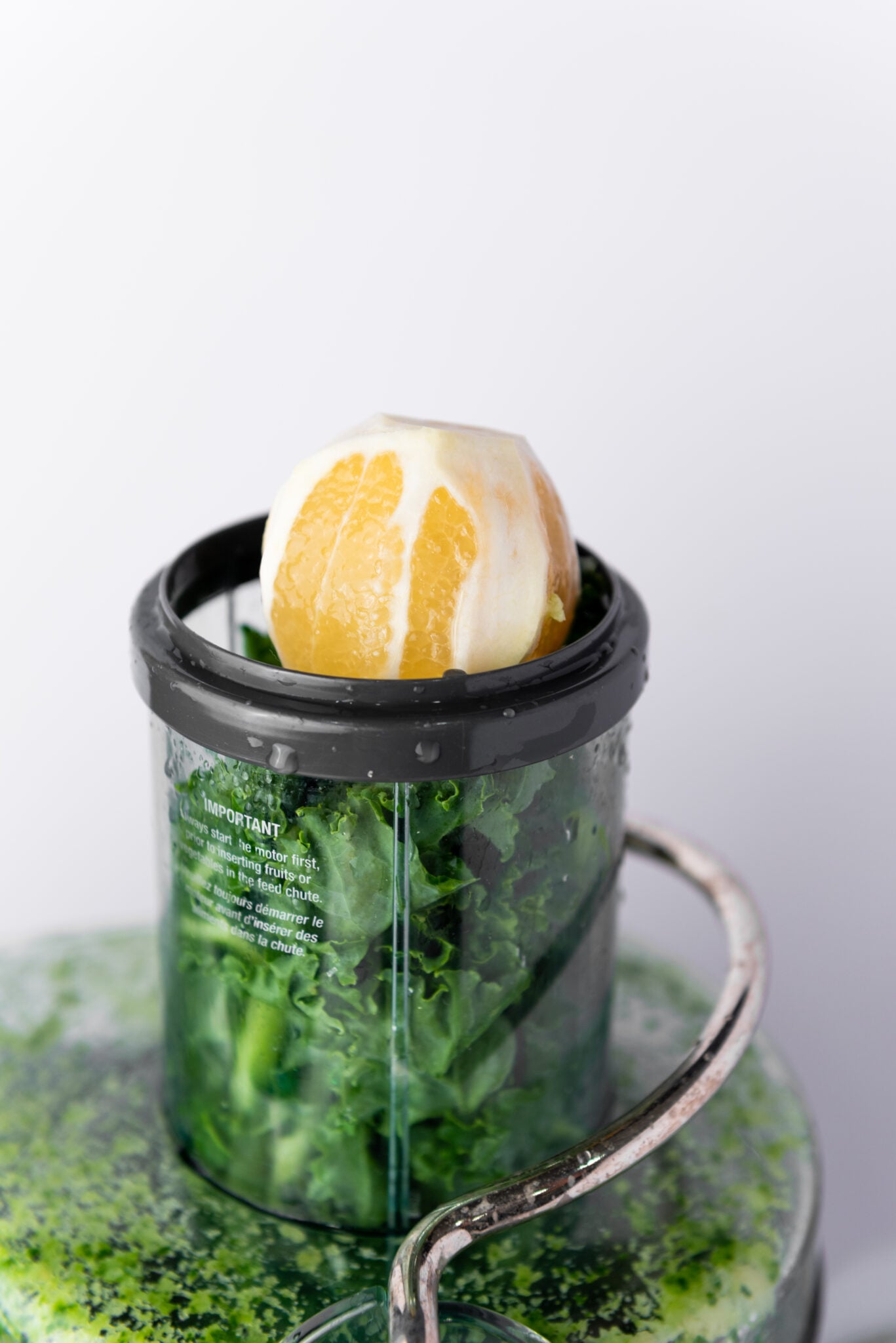 Directly above view of a peeled lemon being juiced, its bright yellow contrasting beautifully with the juicer's surface for green juice recipes.