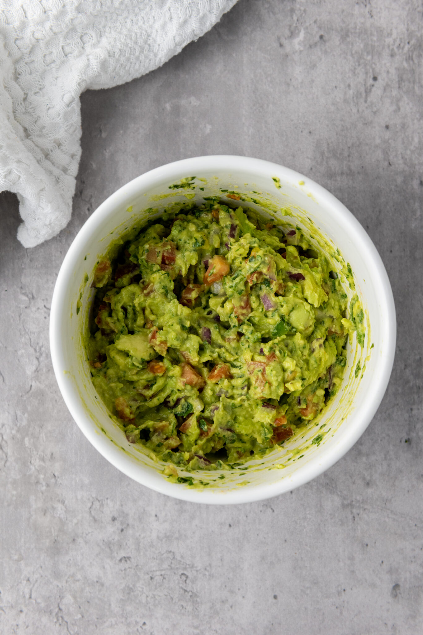 Bowl of guacamole ingredients being mixed together.