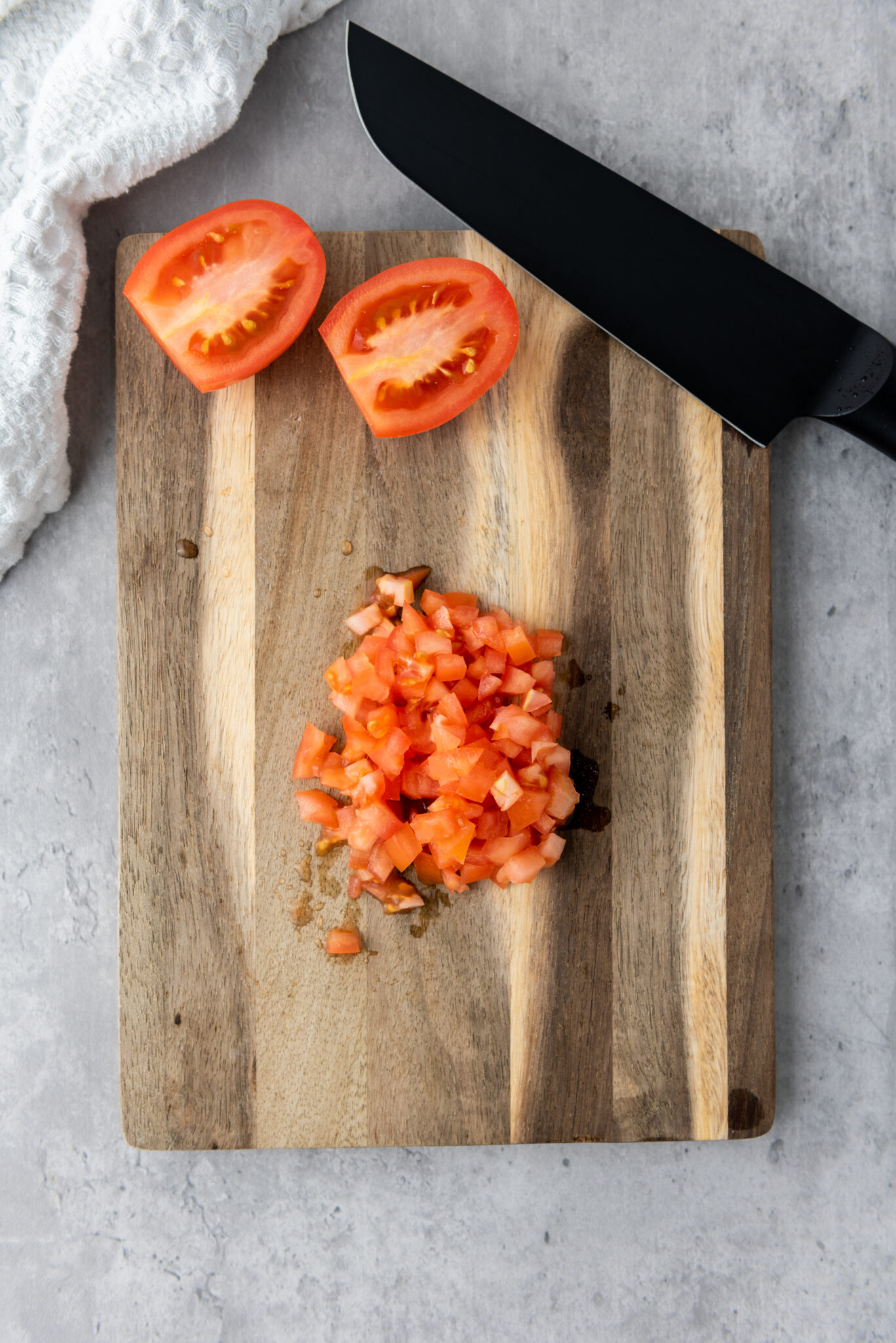 Diced fresh tomatoes on a cutting board.