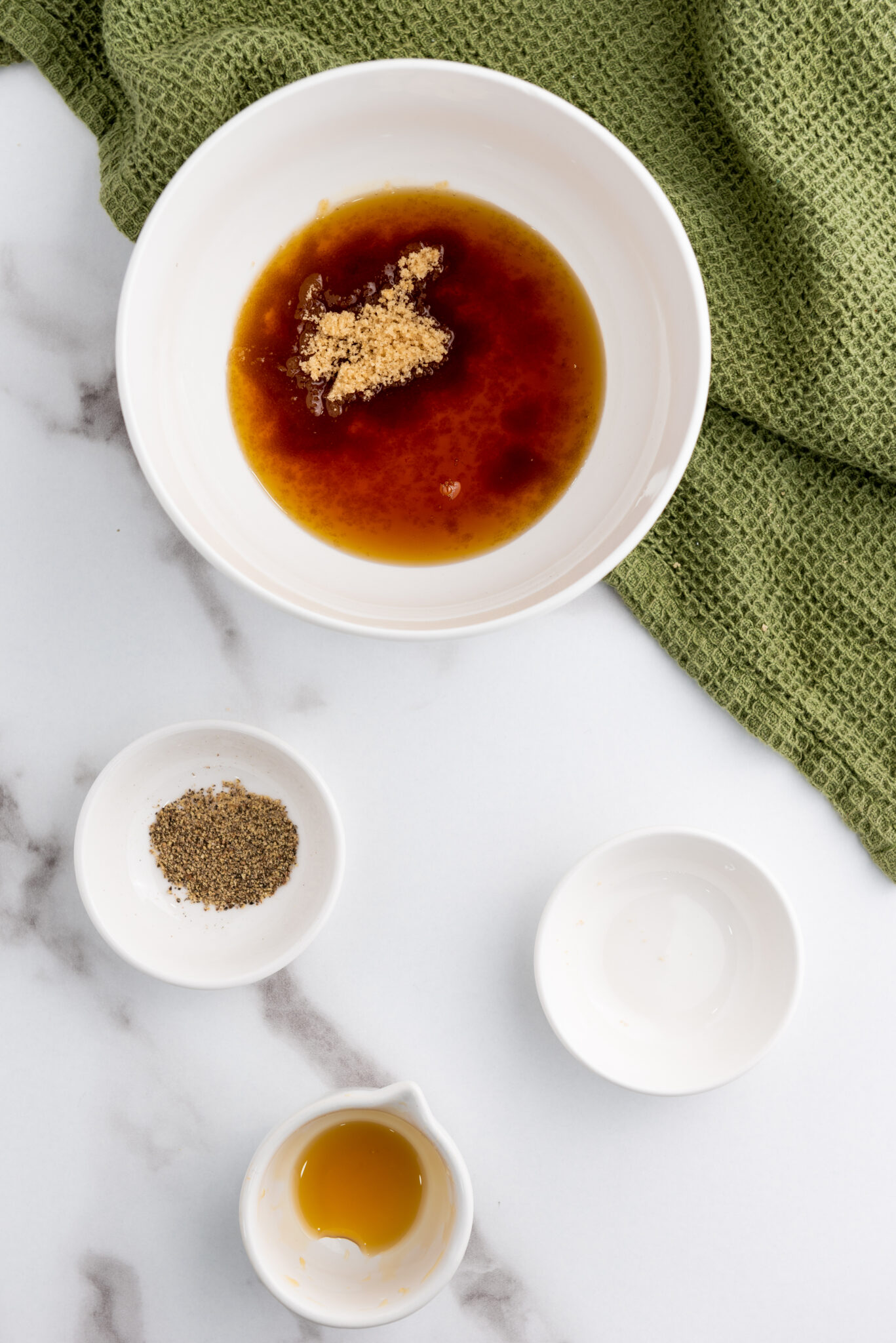 Close-up of maple syrup, brown sugar, and black pepper mixture in a small bowl