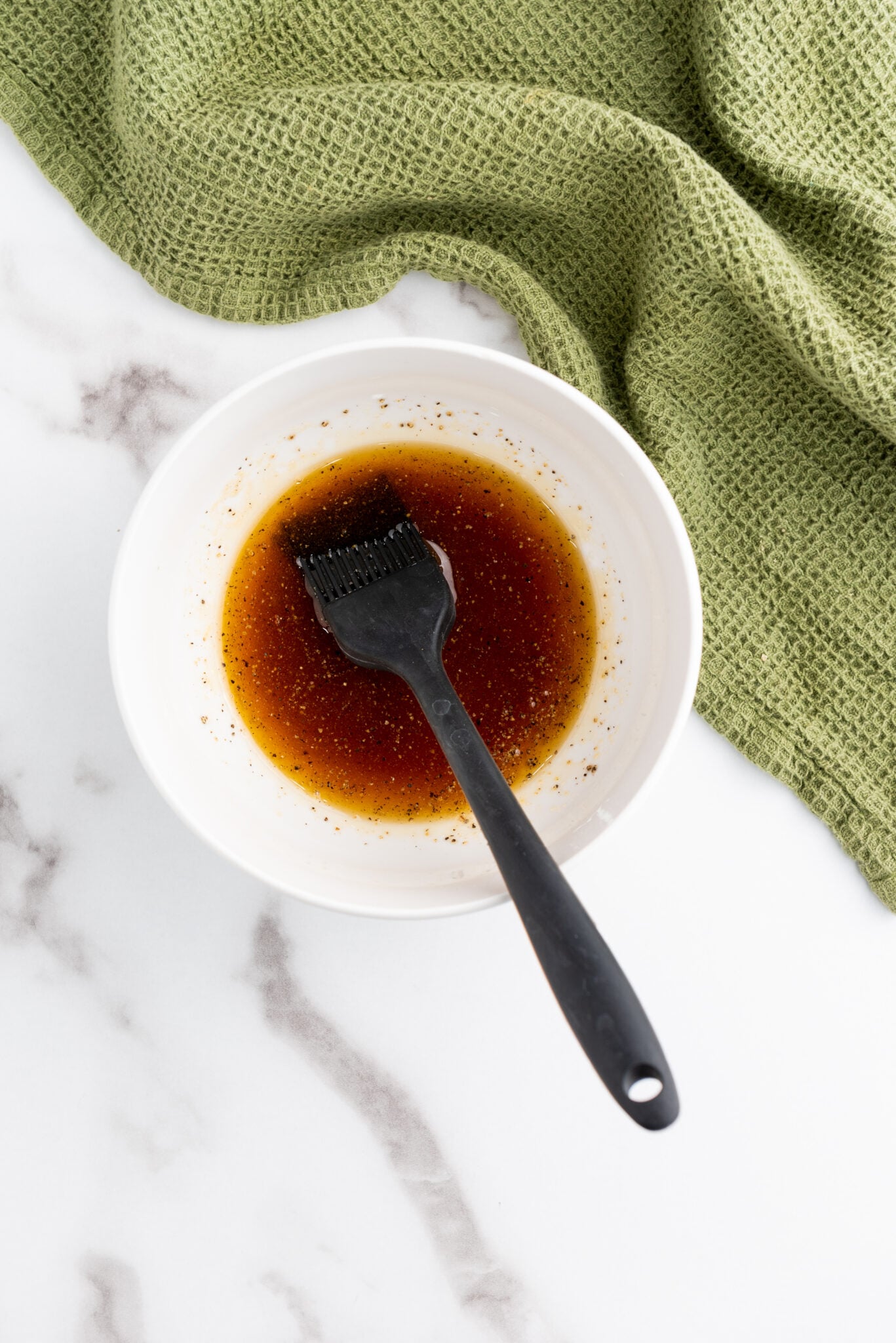 Pastry brush dipping into the brown sugar maple syrup glaze.