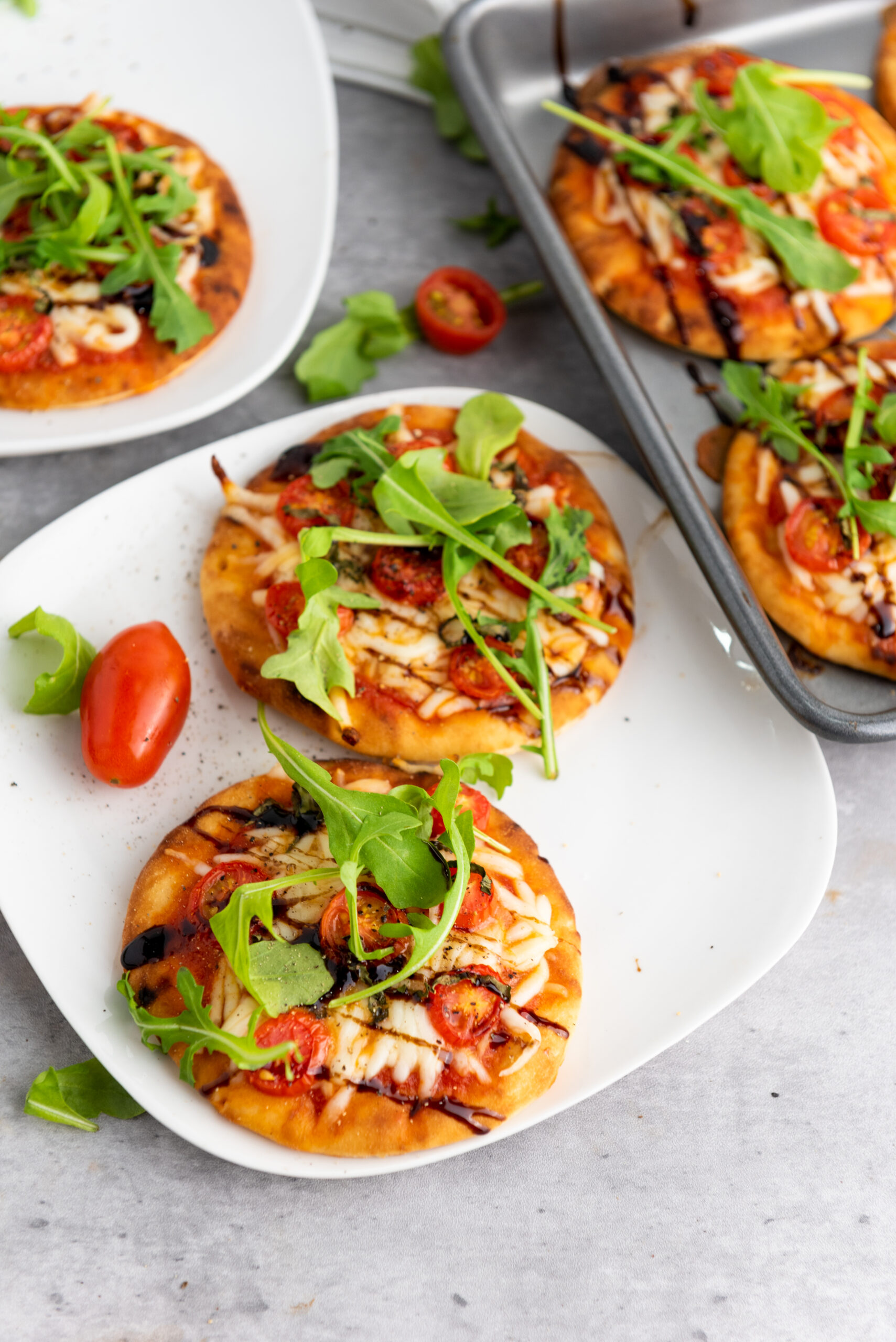 A delightful photo of mini Caprese pizzas, featuring fresh tomato, mozzarella, and basil toppings, perfect for a quick and tasty meal.