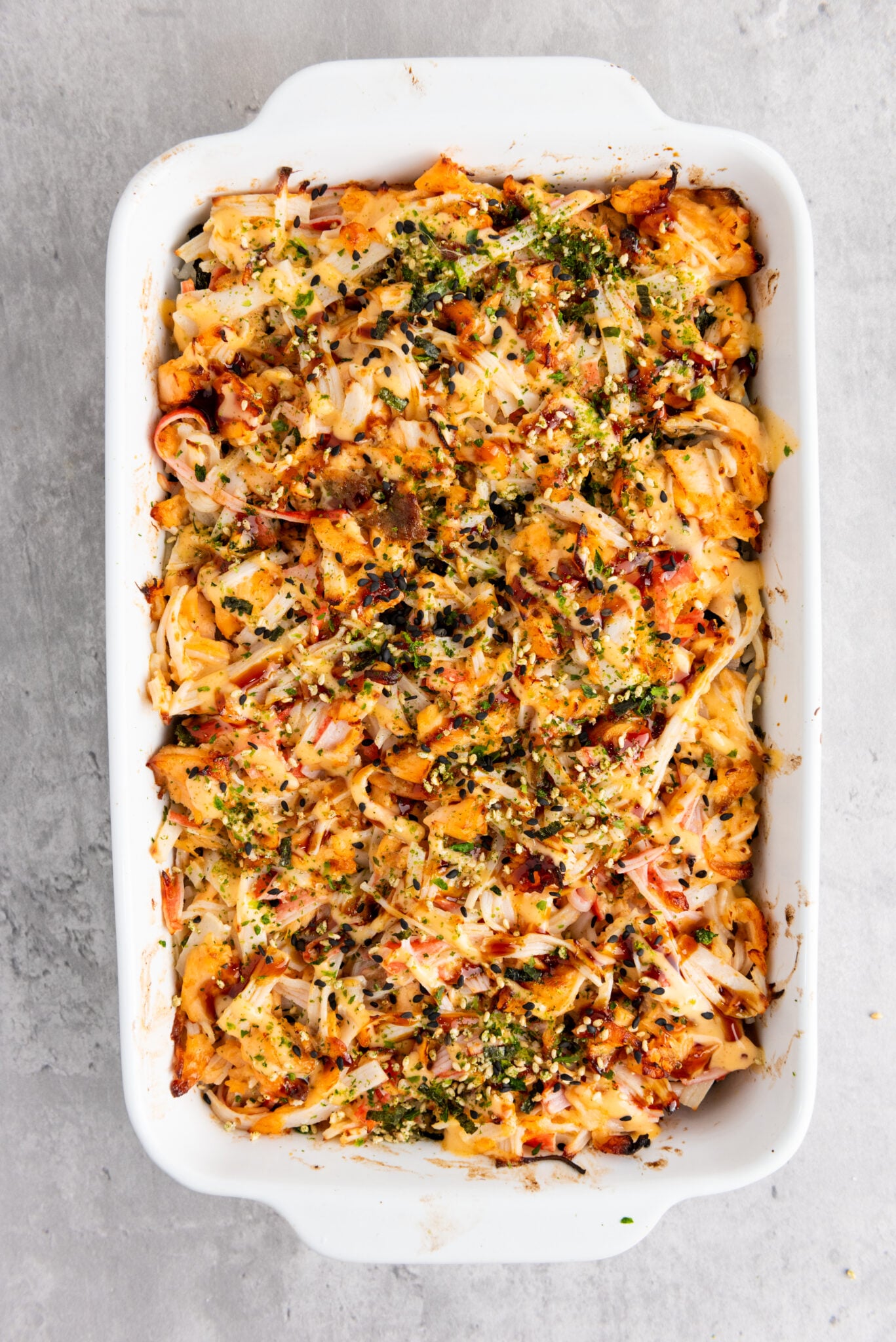 Close-up of sushi bake topped with sauces and seasoning