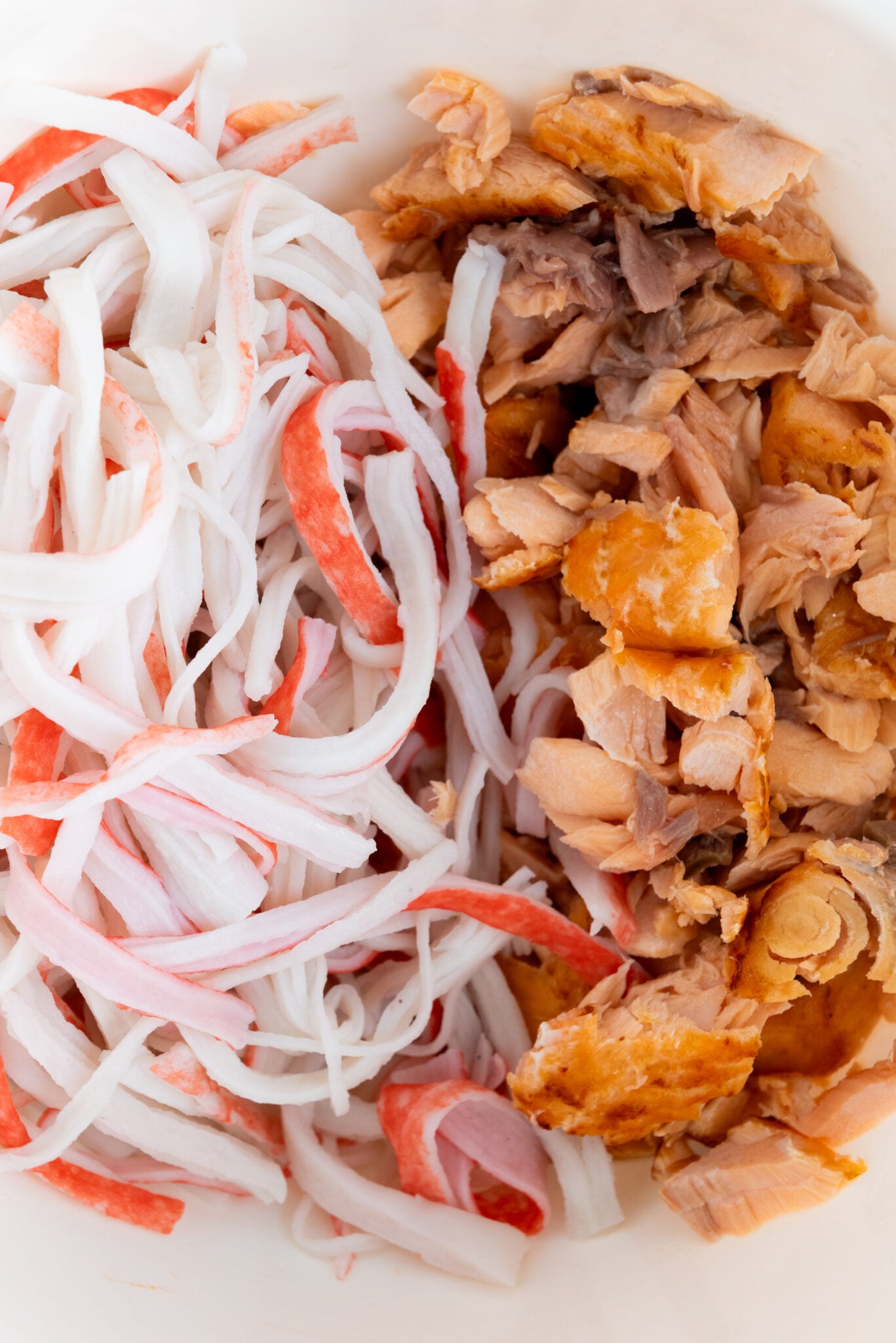 Bowl containing shredded salmon and imitation crab mix.