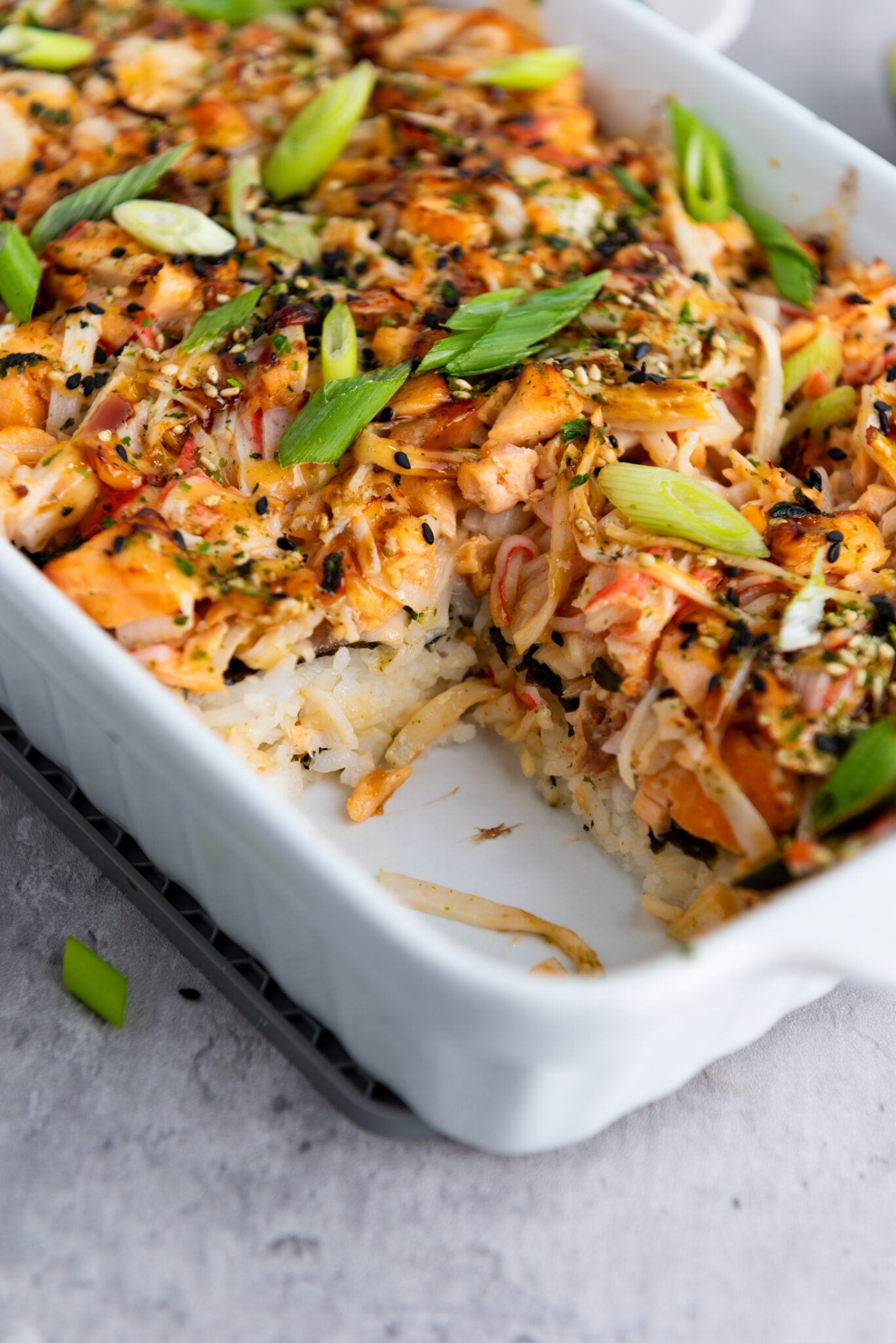 Closer view of sushi bake in the casserole dish highlighting the layered texture.