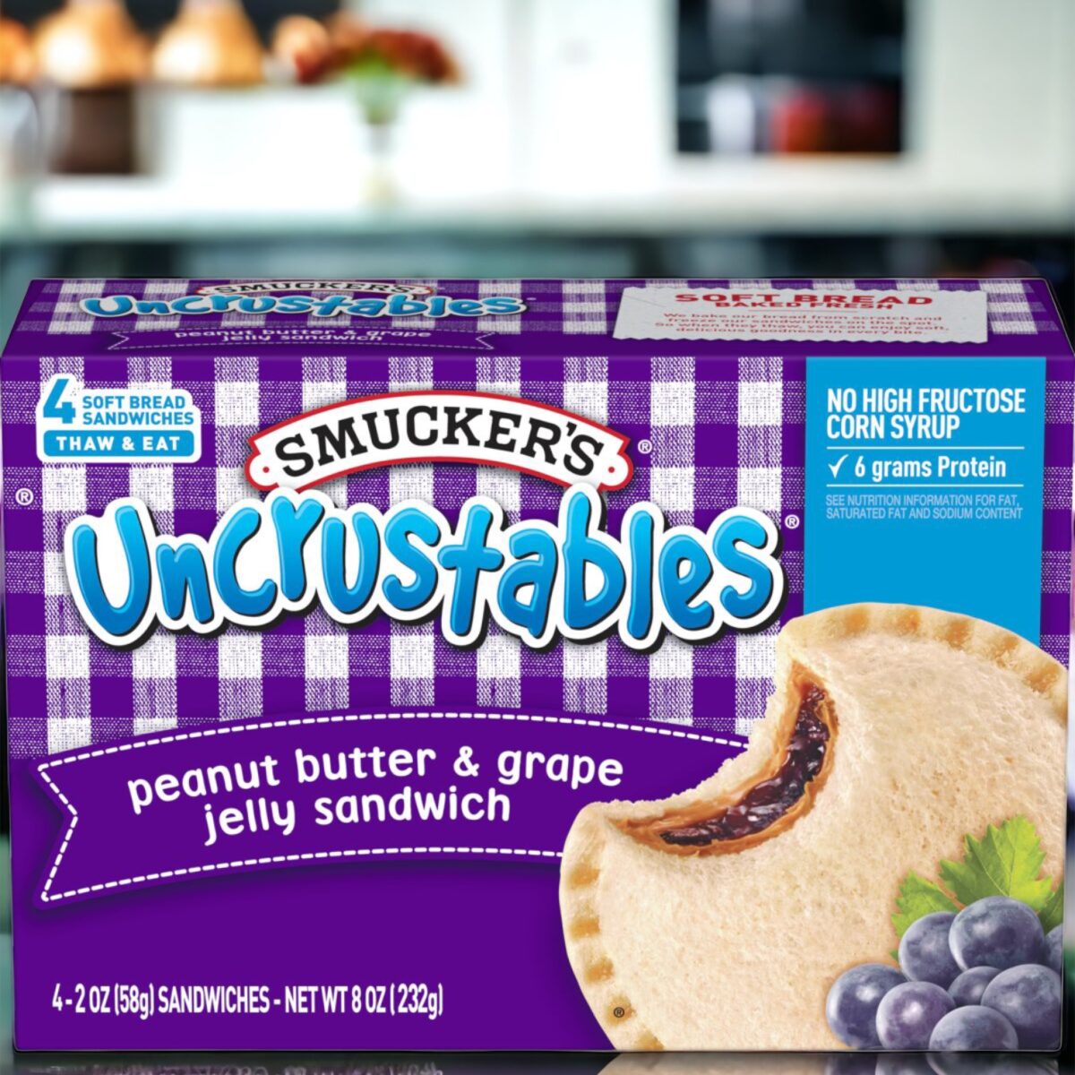 Box of Smucker's Uncrustables peanut butter & grape jelly sandwiches on a countertop, asking if you can put Uncrustables in the toaster.