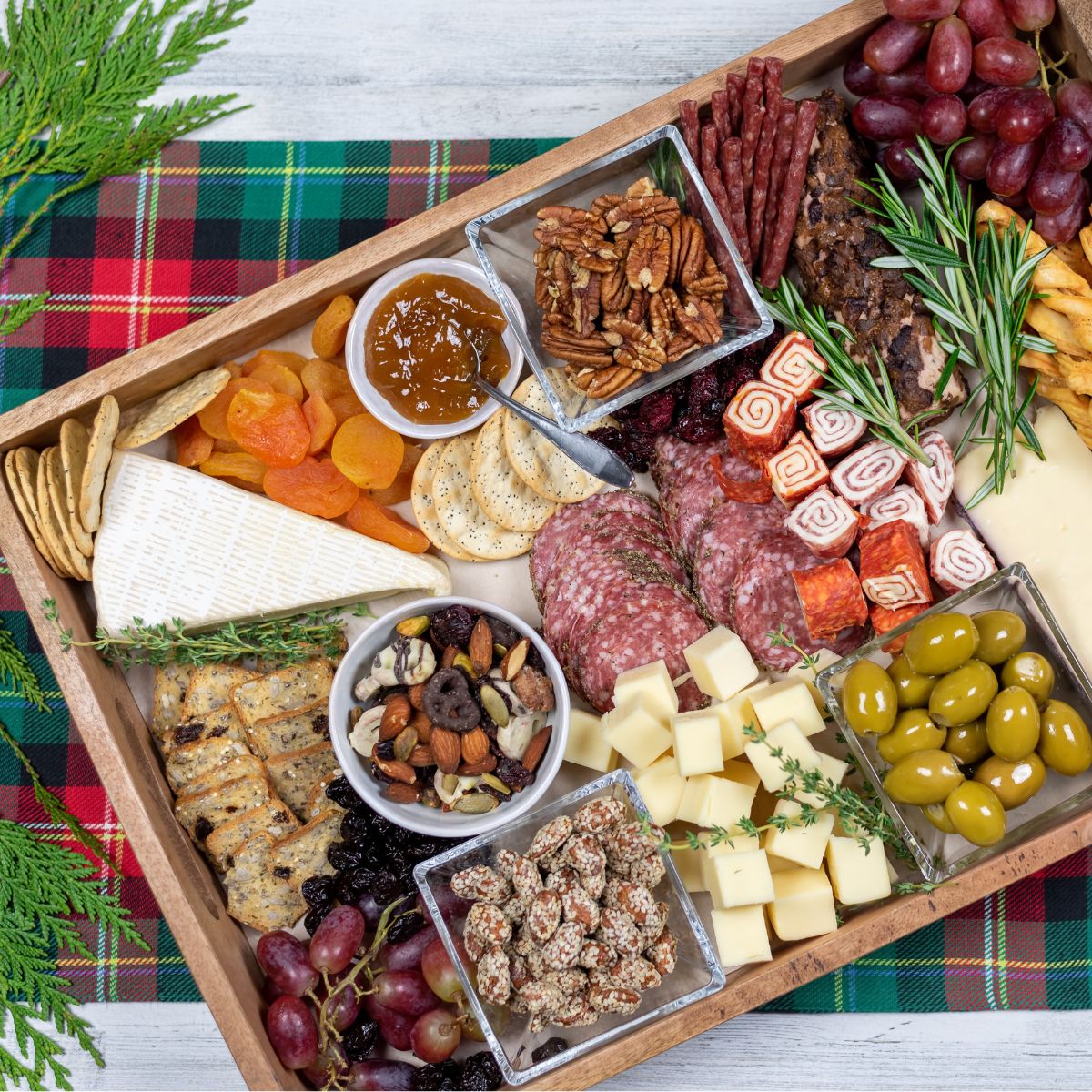 A photograph of a cheese board, showcasing an assortment of cheeses, crackers, fruits, and garnishes artfully arranged on a wooden board.