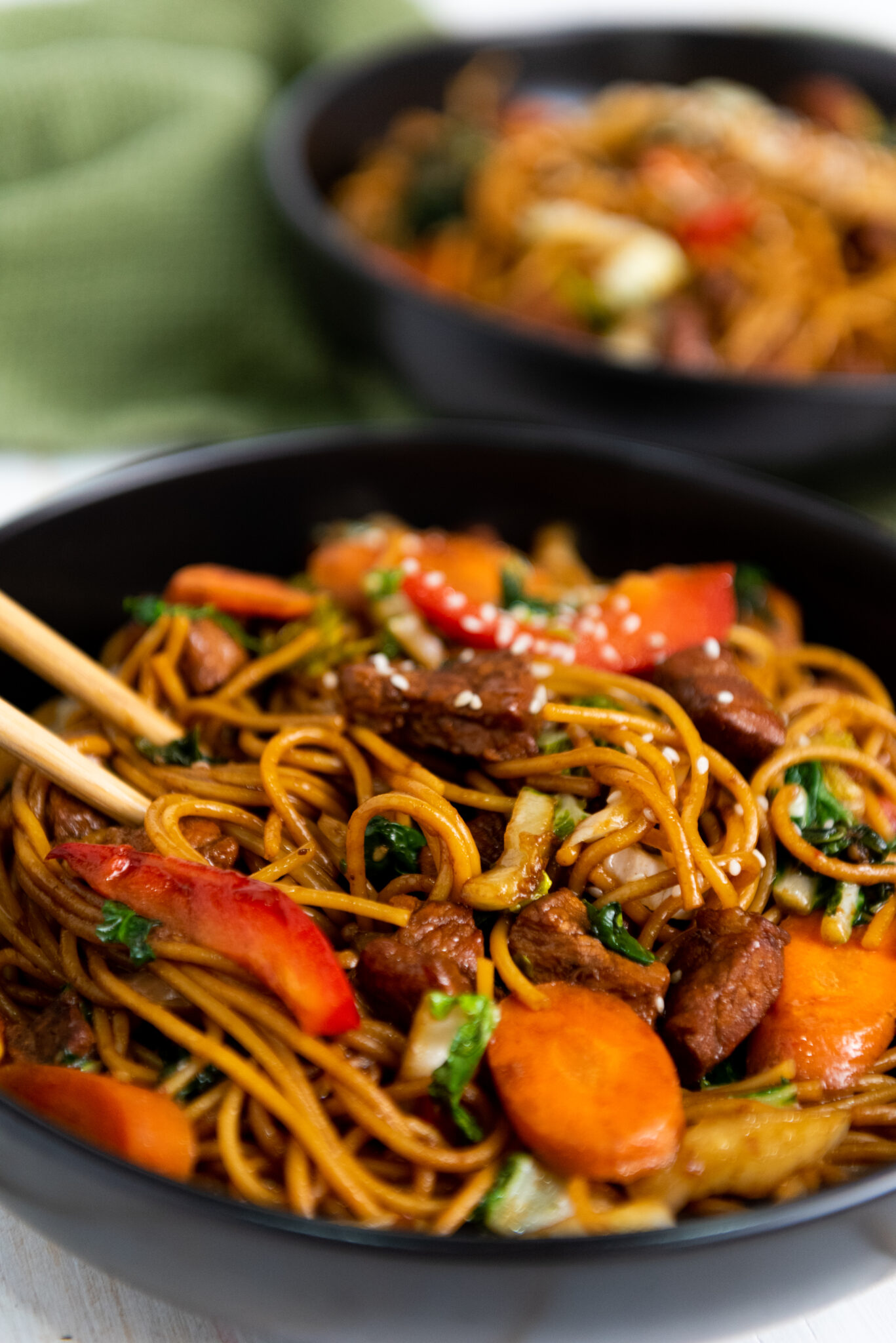 Lo mein on a plate with chop sticks.