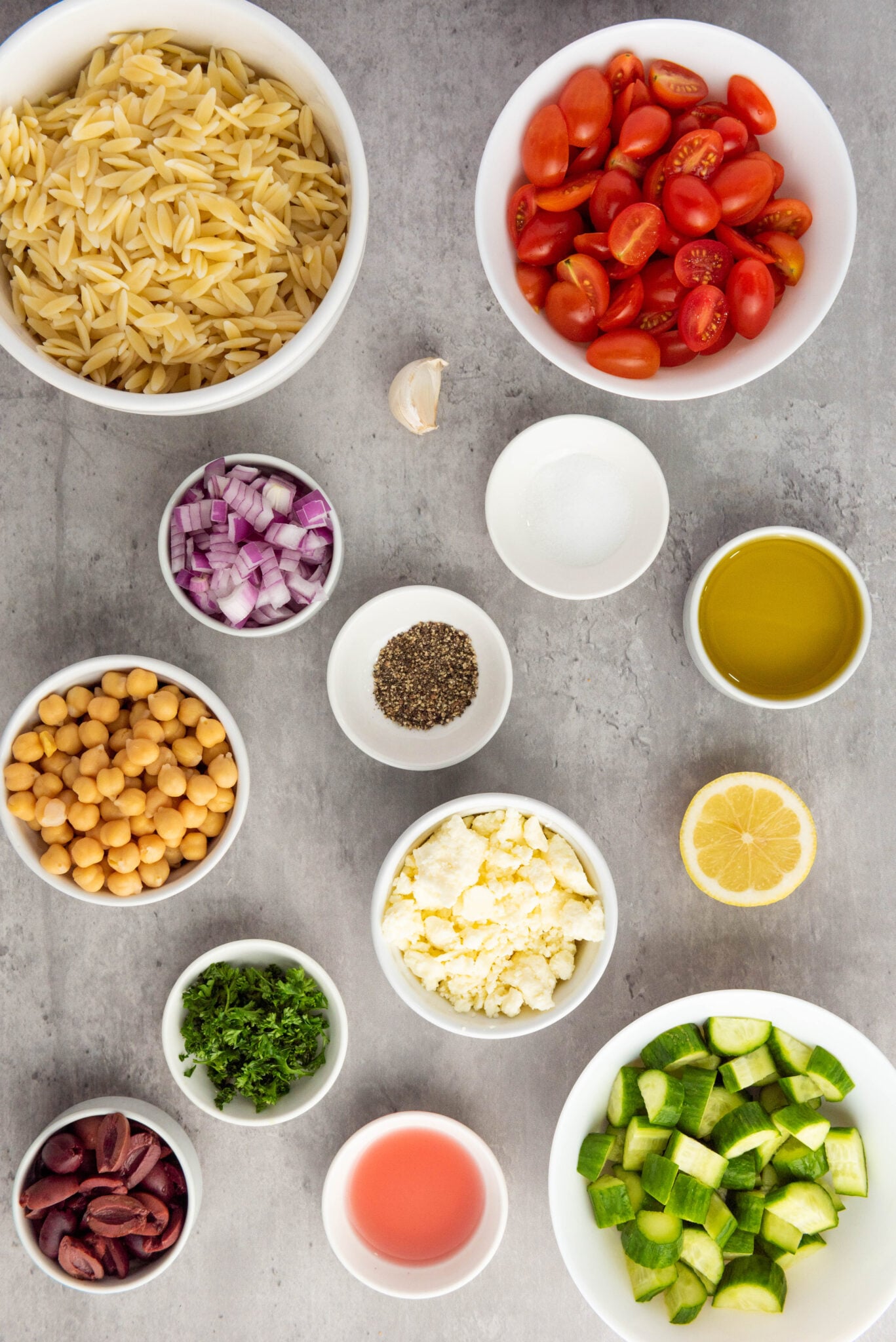 Ingredients for a mediterranean-style salad displayed on a table.