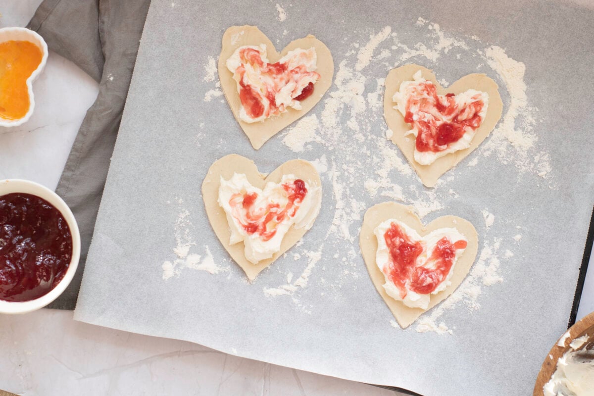 adding cream cheese and jam to pastry sheets